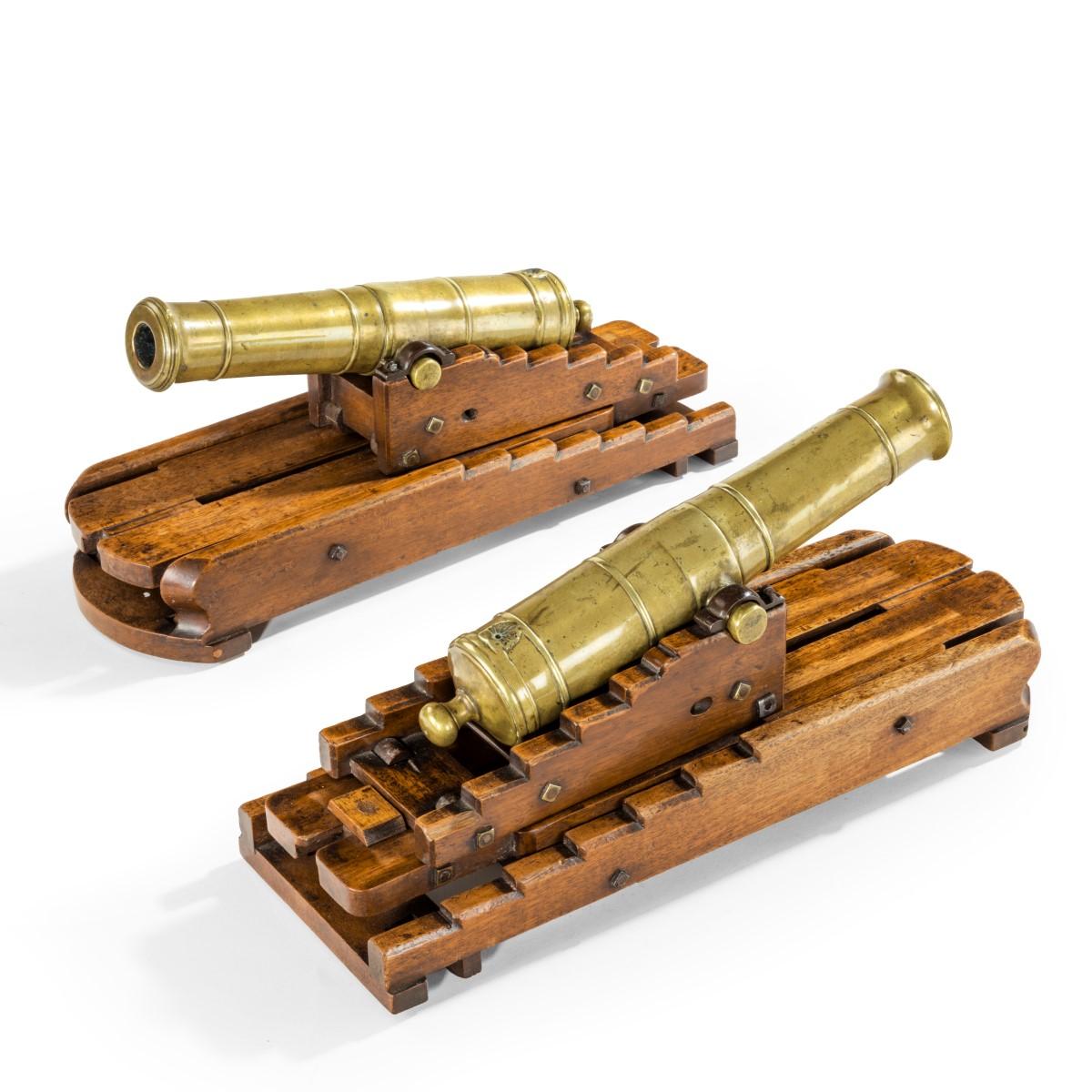 A very good pair of brass 19th century models of ship’s 32-pounder cannon, on stepped mahogany elevating carriages. English, circa 1840.