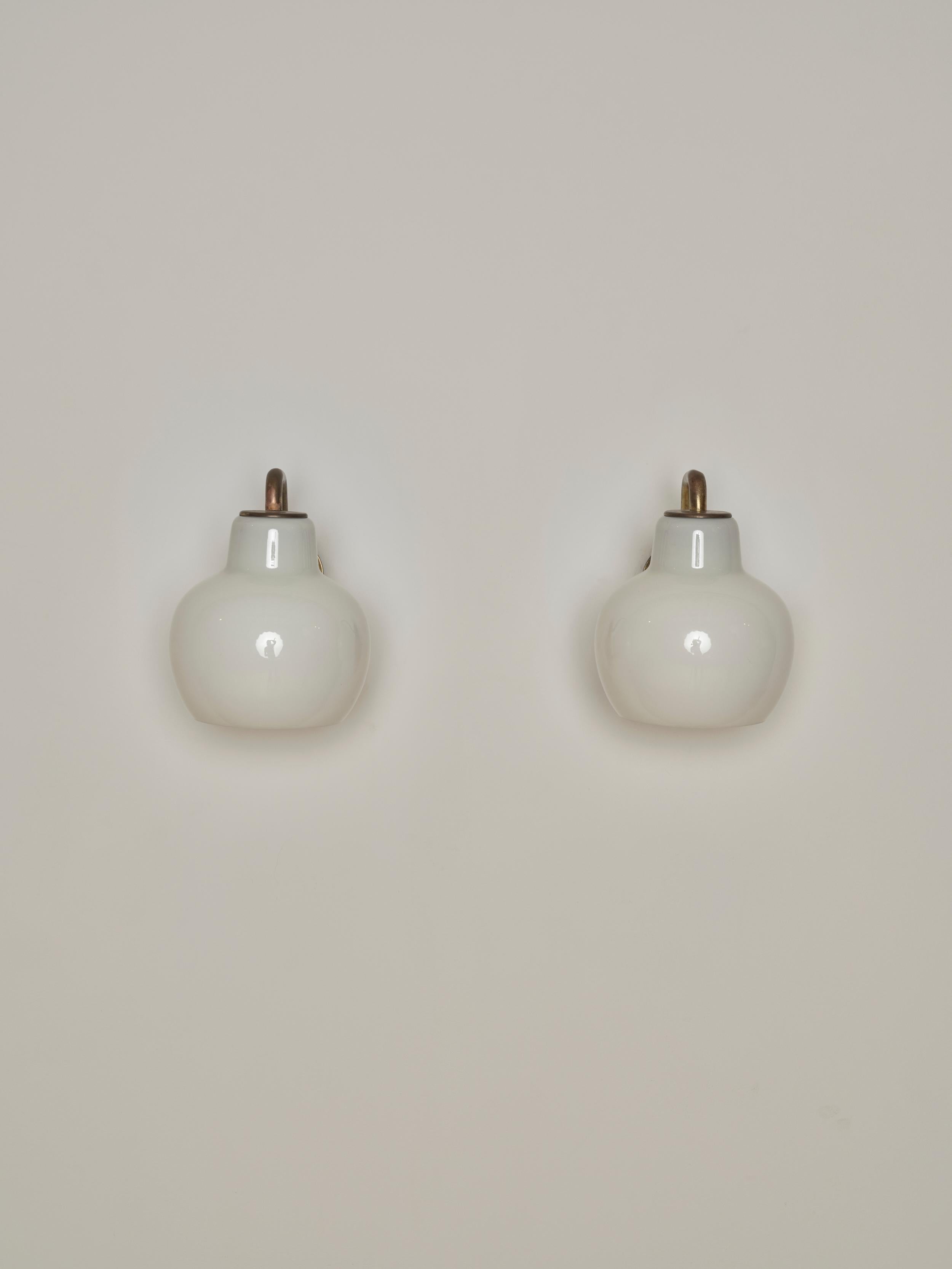 A pair of Brass and Glass Wall Sconces designed by the iconic Vilhelm Lauritzen for Louis Poulsen. These sconces feature solid brass elements while the delicate glass shades provide a soft, diffused, warm light.

