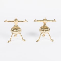 A pair of brass fire dogs by James Cartland & Son