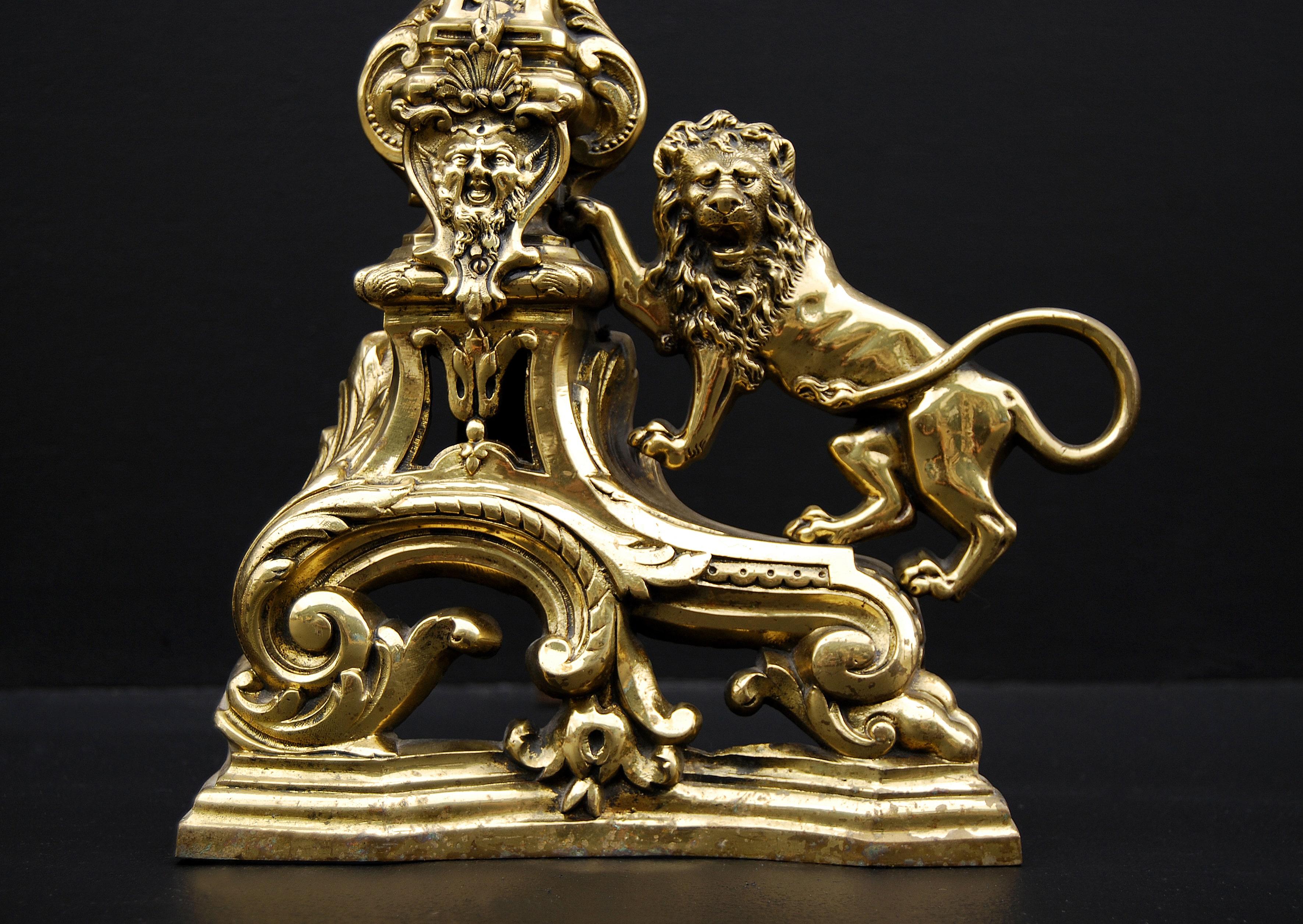 Pair of 20th century French brass firedogs with pinnacle and with lion design to the side.

Measures: Height: 405 mm 16