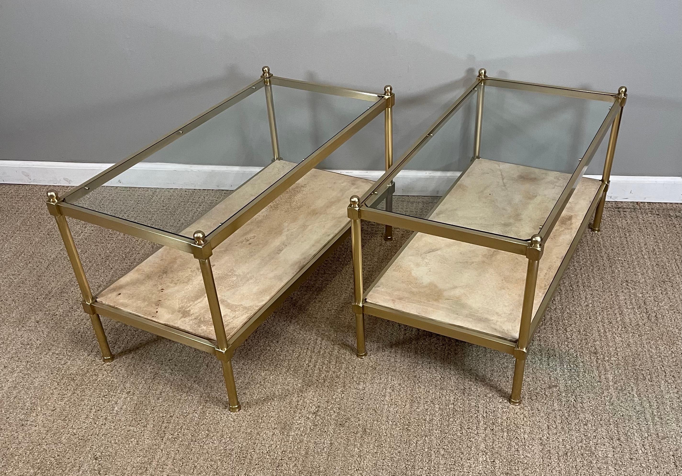 A pair of brass glass & parchment side tables.