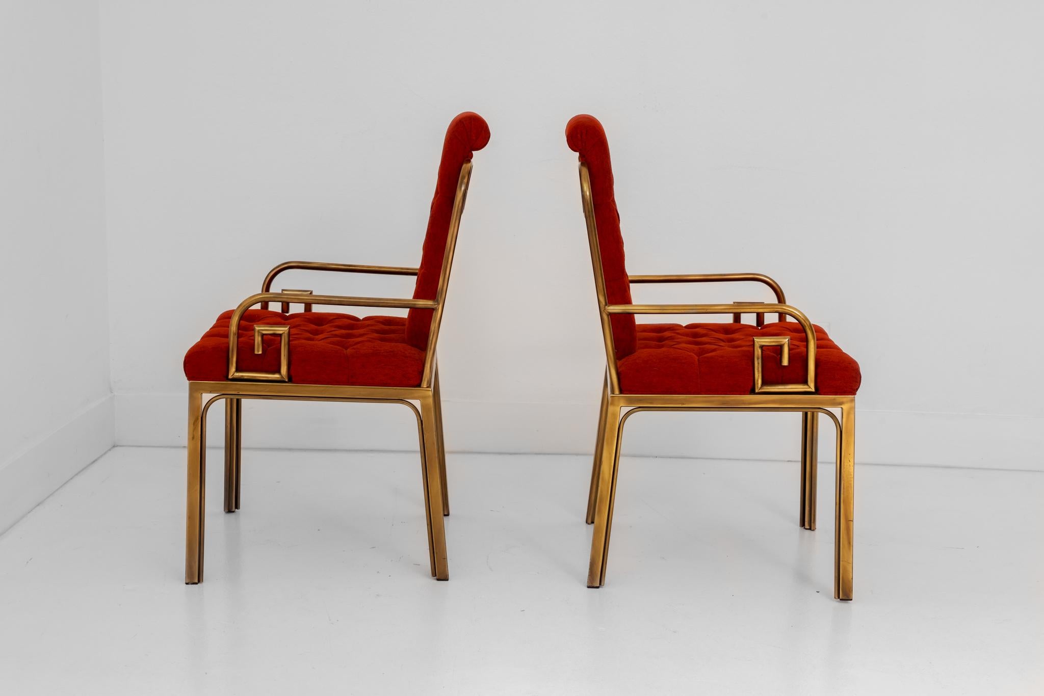 This is a gorgeous pair or original Mastercraft Greek Key arm dining chairs designed by Bernard Rohne. The original fabric is a deep burnt orange, both the seats and backs are tufted adding to the interest of these chairs. The original patina is a