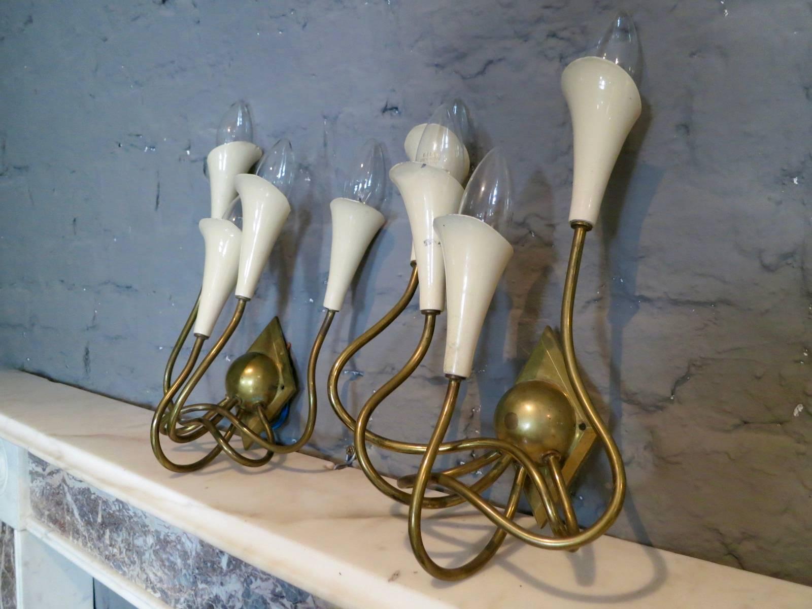 A pair of wall lights in organic form, with four lights each. The ivory enameled bulb holders in original condition. Can be re painted if desired.