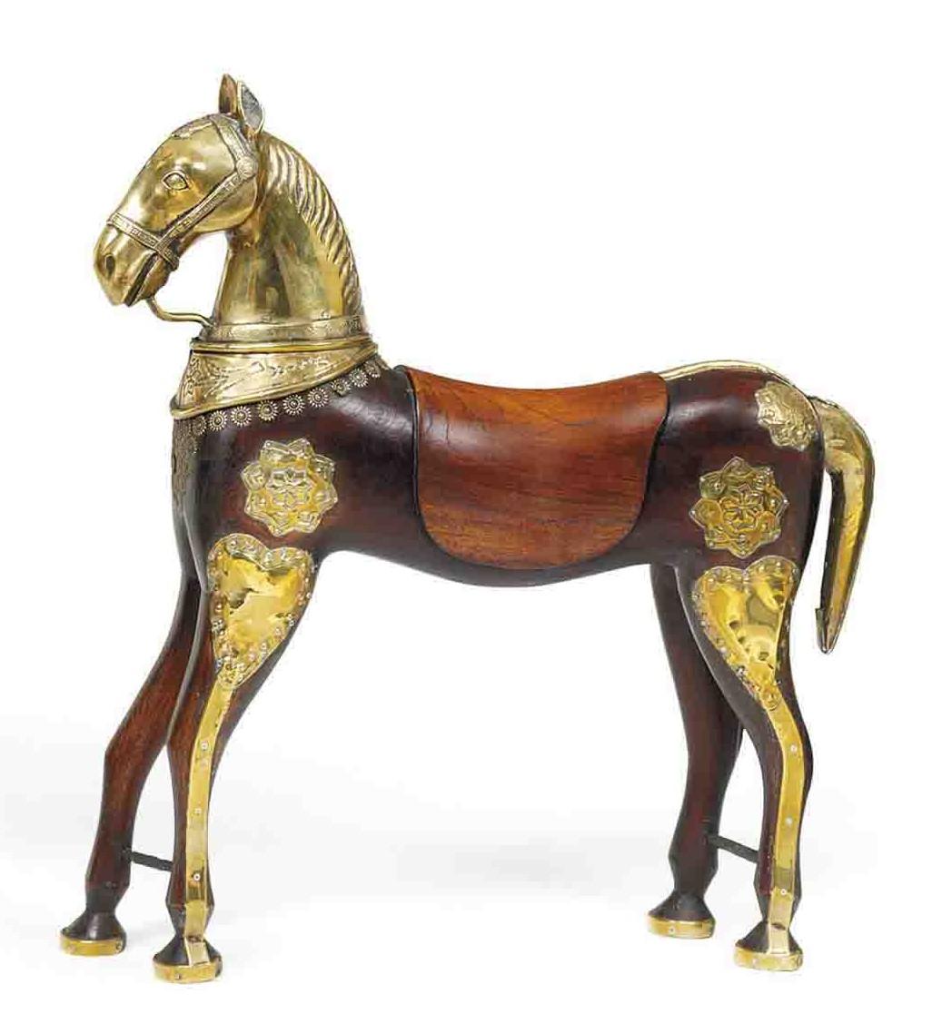 UNE PAIRE DE CHEVAUX DE PROCESSION EN TECK MONTÉS SUR LAITON
FIN DU 19E SIÈCLE, PROBABLEMENT INDE DU SUD
Les corps allongés sont magnifiquement sculptés avec des montures gravées et décorées de laiton poinçonné.
Dans les mariages indiens