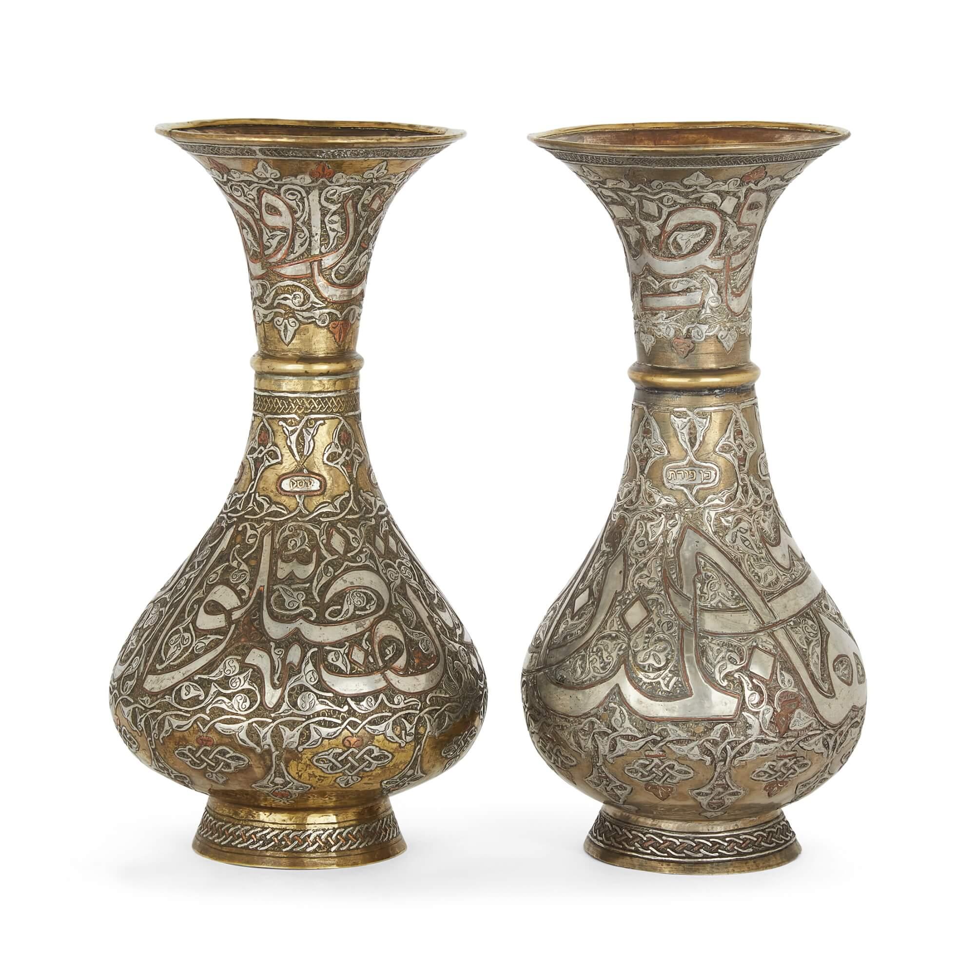 A pair of brass Syrian Mamluk revival vases with silver and copper inlay
Syrian, 20th Century
28cm high x 14cm in diameter.

These excellent vases were made in the Mamluk revival, during which inspiration was drawn heavily from the Mamluk