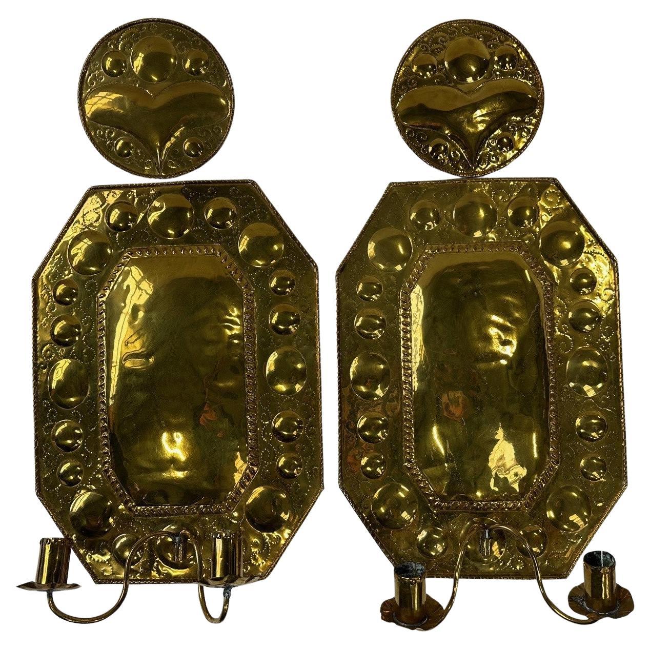 Paire de boucliers muraux en laiton, avec deux chandeliers. Décoré