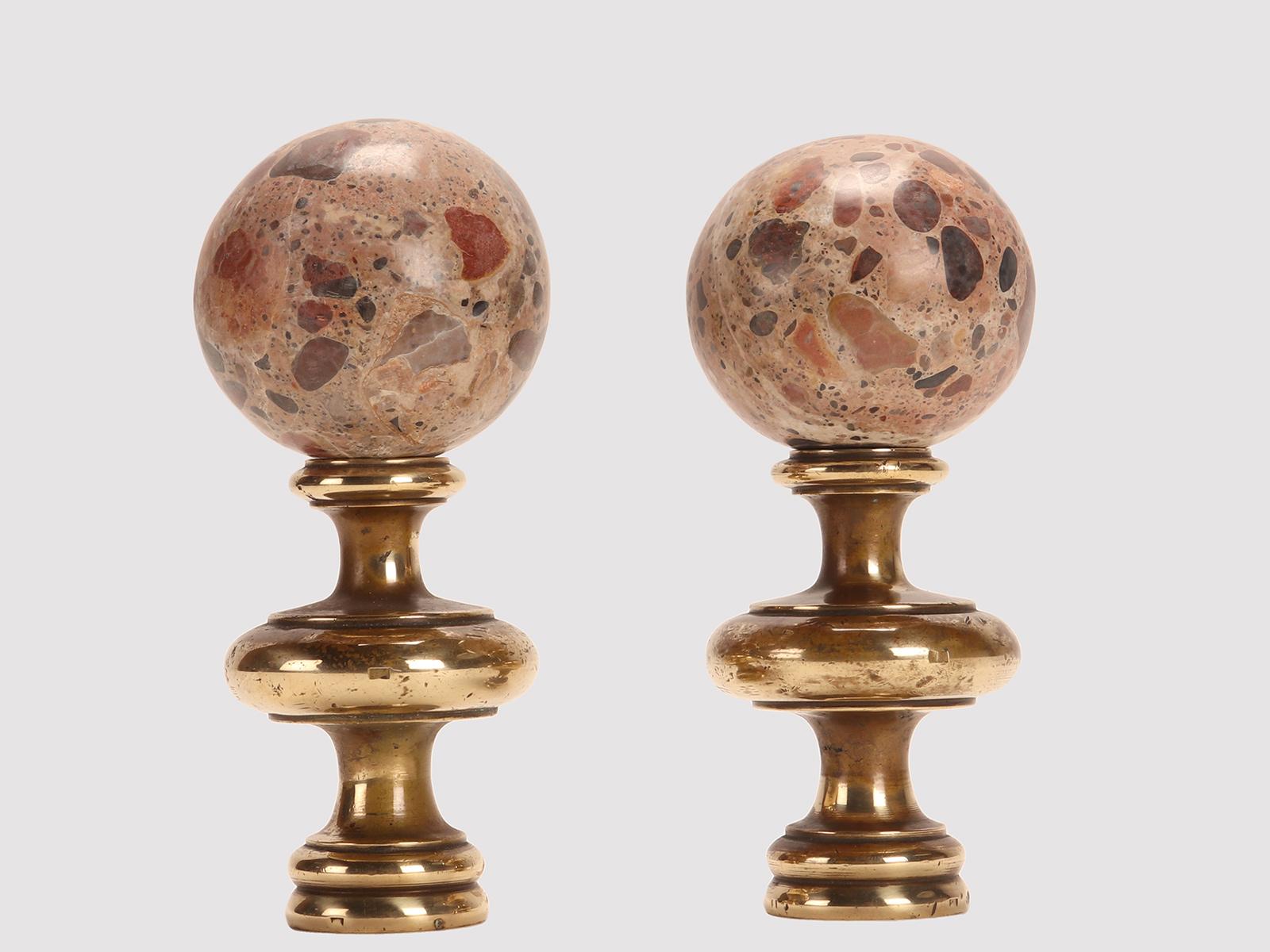 A pair of spheres in brecciated marble Paradise, resting on a circular bronze base with a wavy profile and a central excrescent disk. Italy, late 19th century.