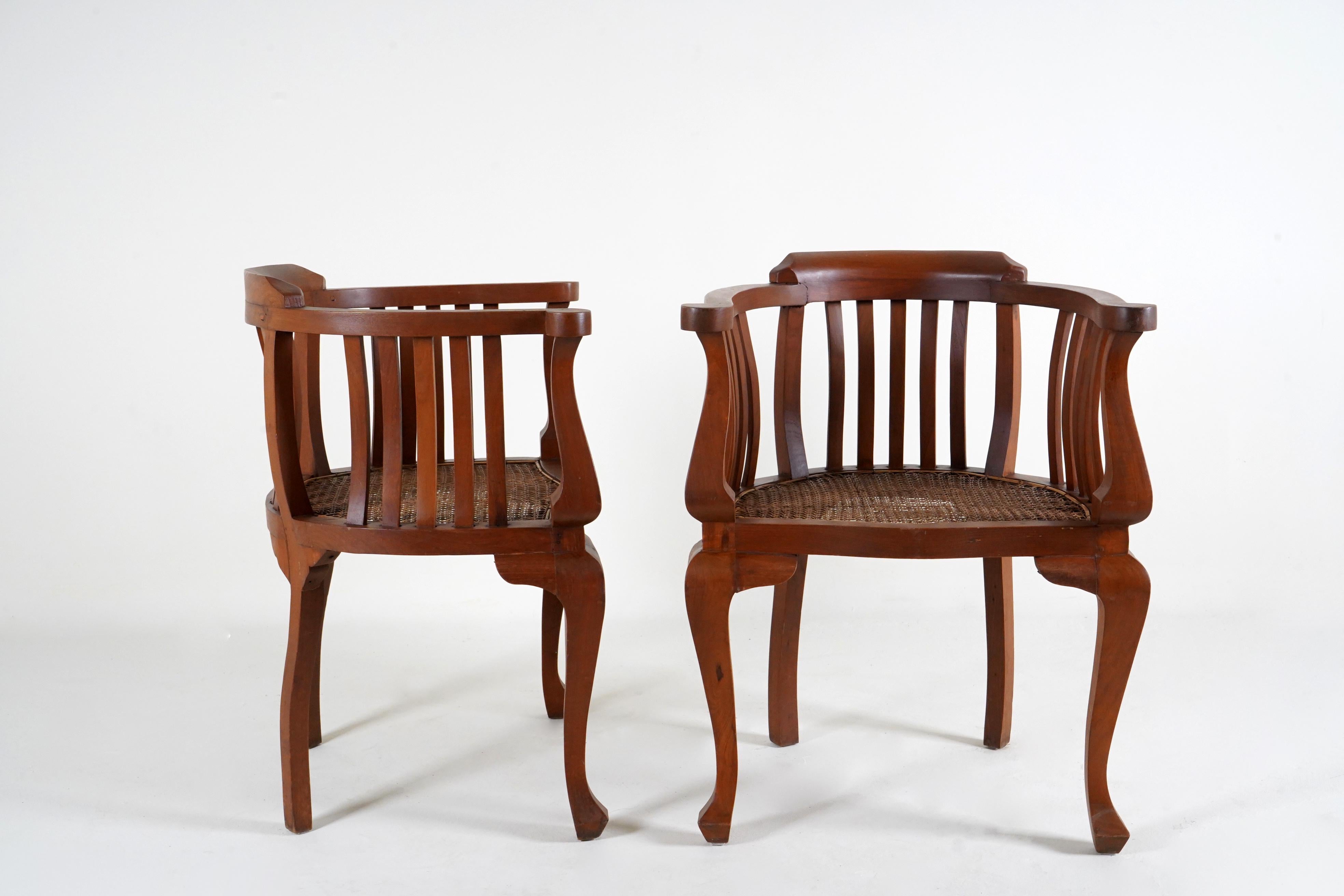A Pair of British Colonial Teak Arm Chairs With Rattan Seats In Good Condition In Chicago, IL