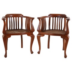 A Pair of British Colonial Teak Arm Chairs With Rattan Seats