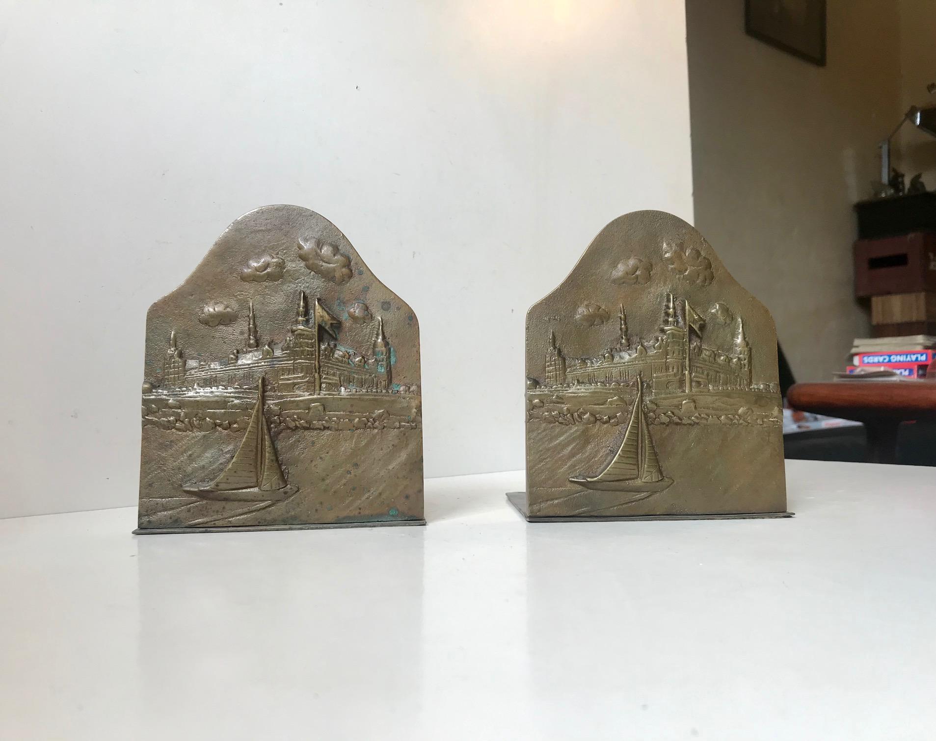 A pair of solid bronze bookends. Designed and manufactured by Ægte Klokke Bronze in Denmark during the 1920s or 1930s. The bookends features a relief image of Kronborg Castle in Denmark seen from the Sea. Kronborg was the setting of Shakespeares