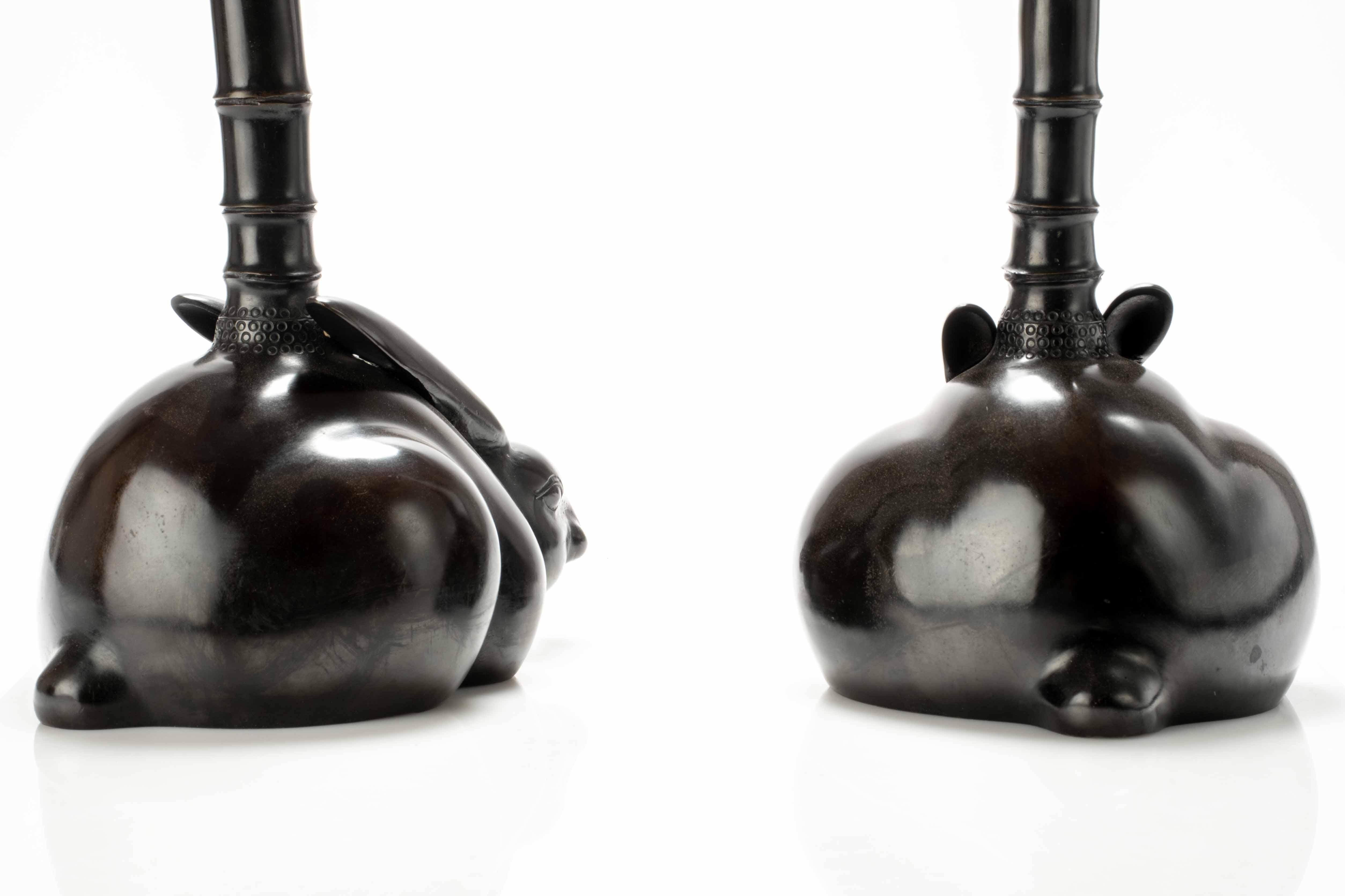 20th Century A pair of bronze candlesticks depicting two rabbits