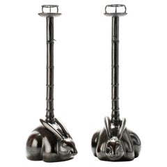 A pair of bronze candlesticks depicting two rabbits
