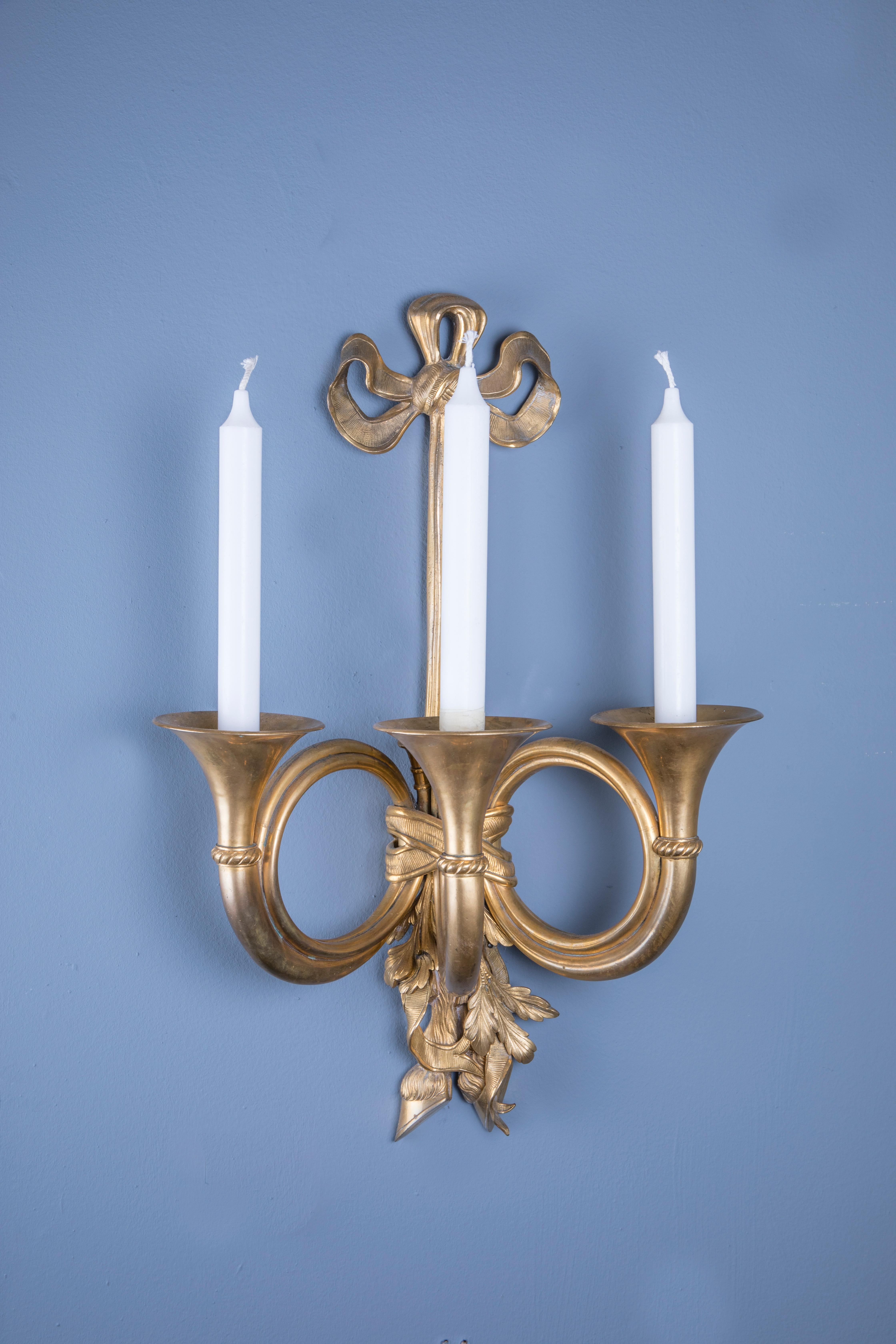 A pair of bronze Louis XVI style pair of hunting horn three branch wall lights.
The branches in the style of French horns, and the back plates with trophy details.
Can be electrified at no extra cost for Europe or North America.