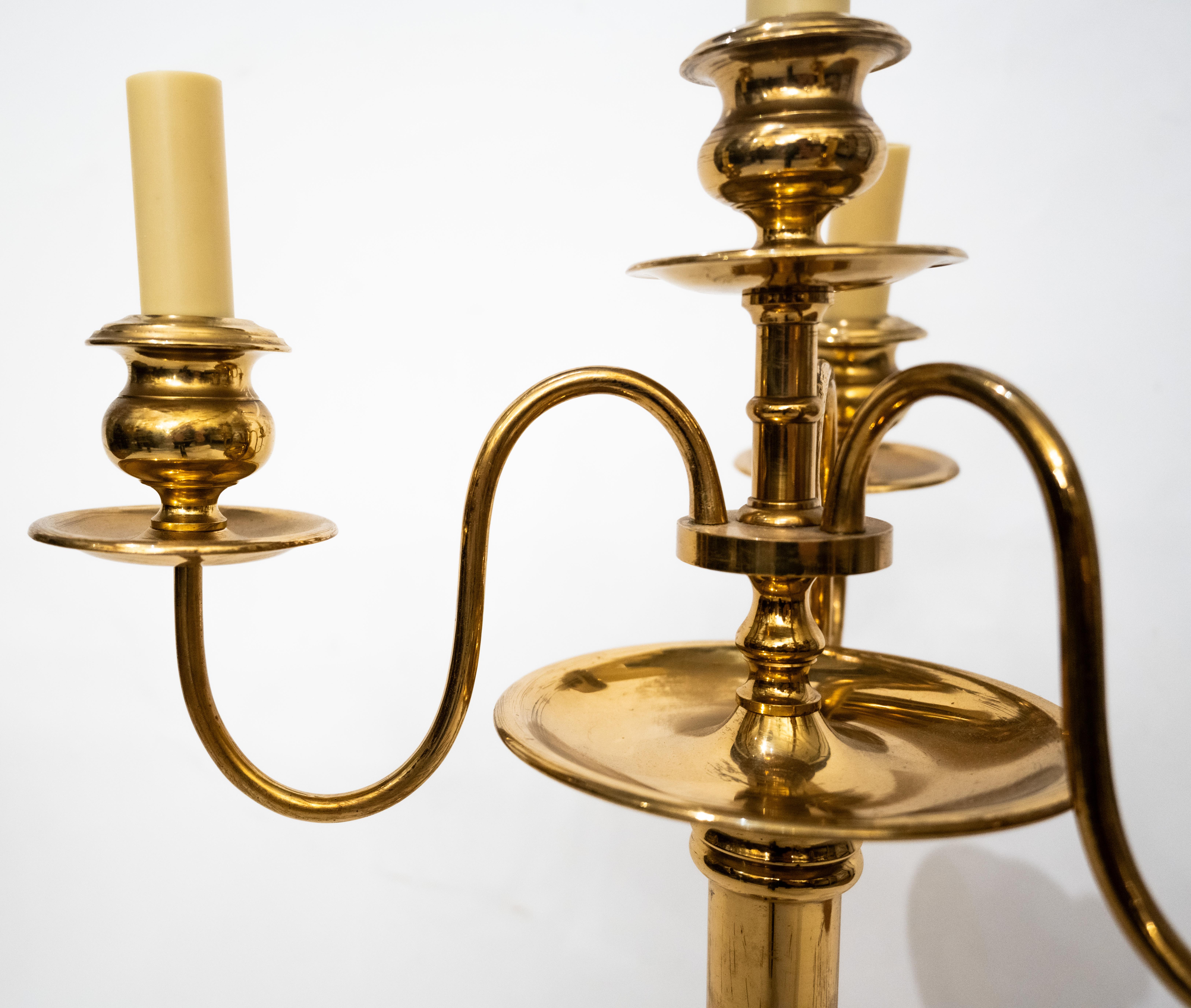 A pair of four-light Skultuna bronze candlesticks with three upswept branches, issuing from the center candlestick with original patina and lacquer and a unique bronze stem. Can be used as a candelabra or converted into a bouillotte light.