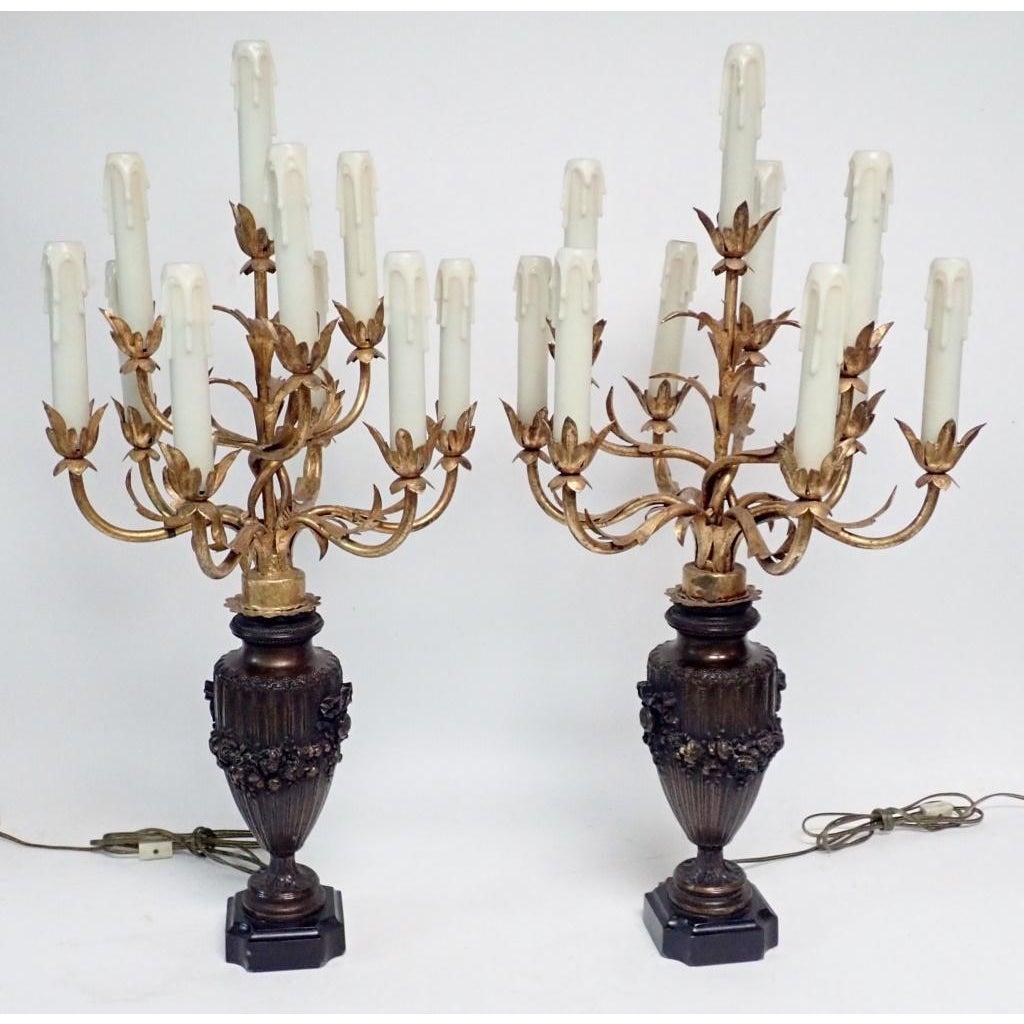 A Pair of Bronzed and Gilt Candelabra. Pair of ten-arm electrified table chandelier lamps with gilt tole candelabra tops and patinated urn form bases.