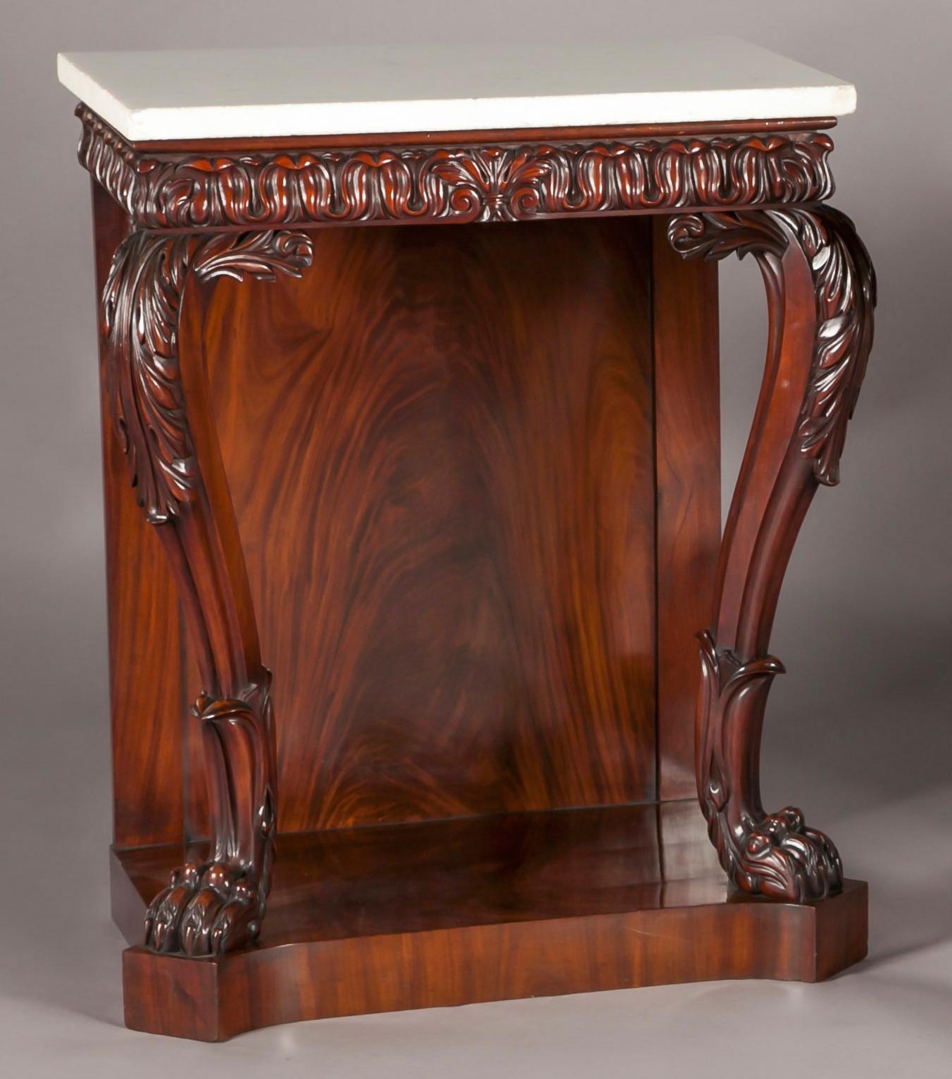 A pair of Irish Regency mahogany console tables, the rectangular Carrara marble tops, above a lotus leaf carved frieze, resting on bold Acanthus carved cabriole legs, with lions paw feet, resting on a plate-form base.
Probably by Mack, Williams and