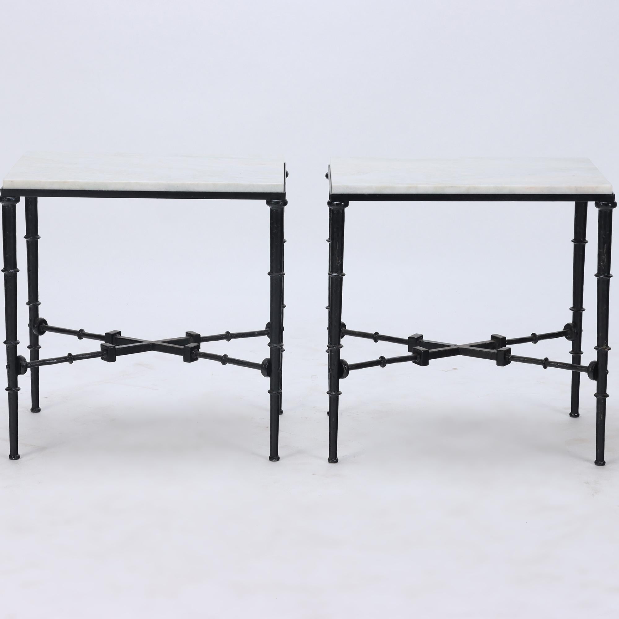 A pair of brutalist style iron and marble top tables in the manner of Giacometti. The white marble tops having a hint of cream. C 1960.
