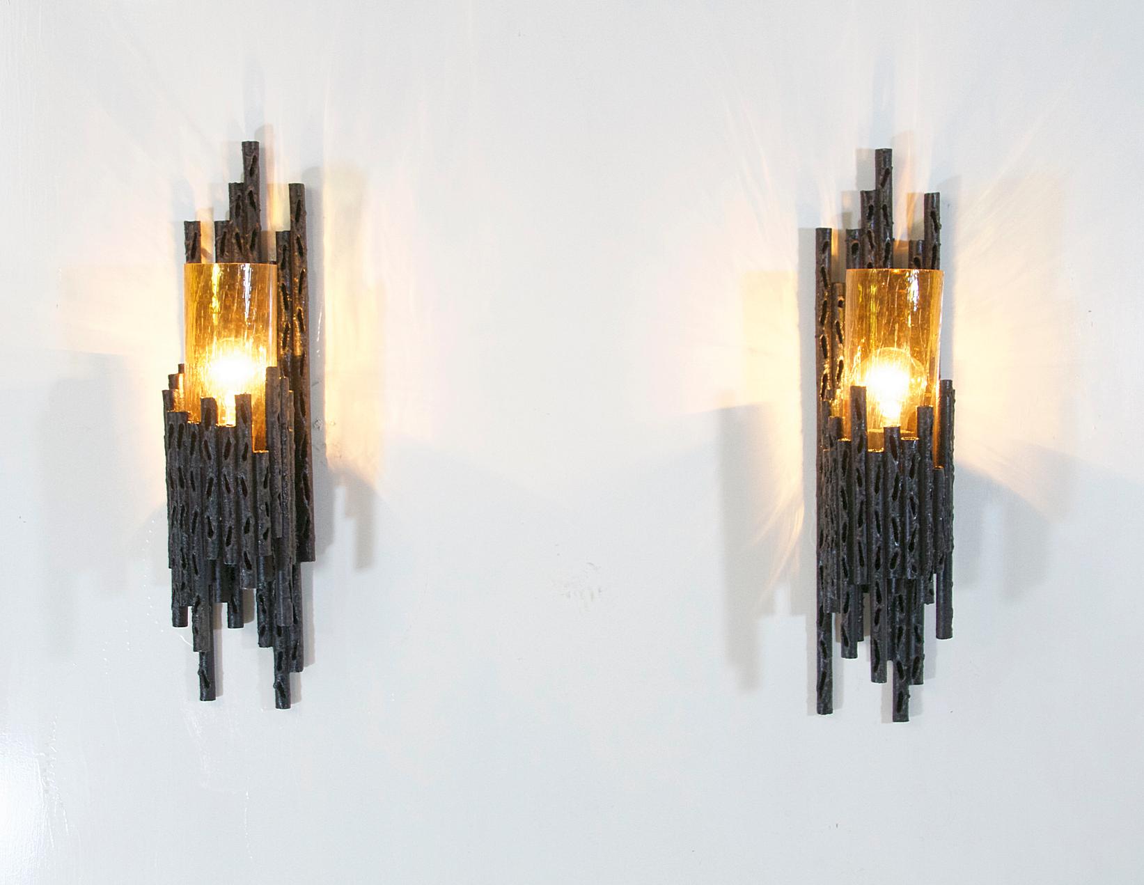 A pair of brutalist wall lamp designed by renowned designer and artist Marcello Fantoni and produced in Italy. Beautiful sculptured torch cut steel with orange tinted glass which gives a nice warm glow. In nice restored condition.
  