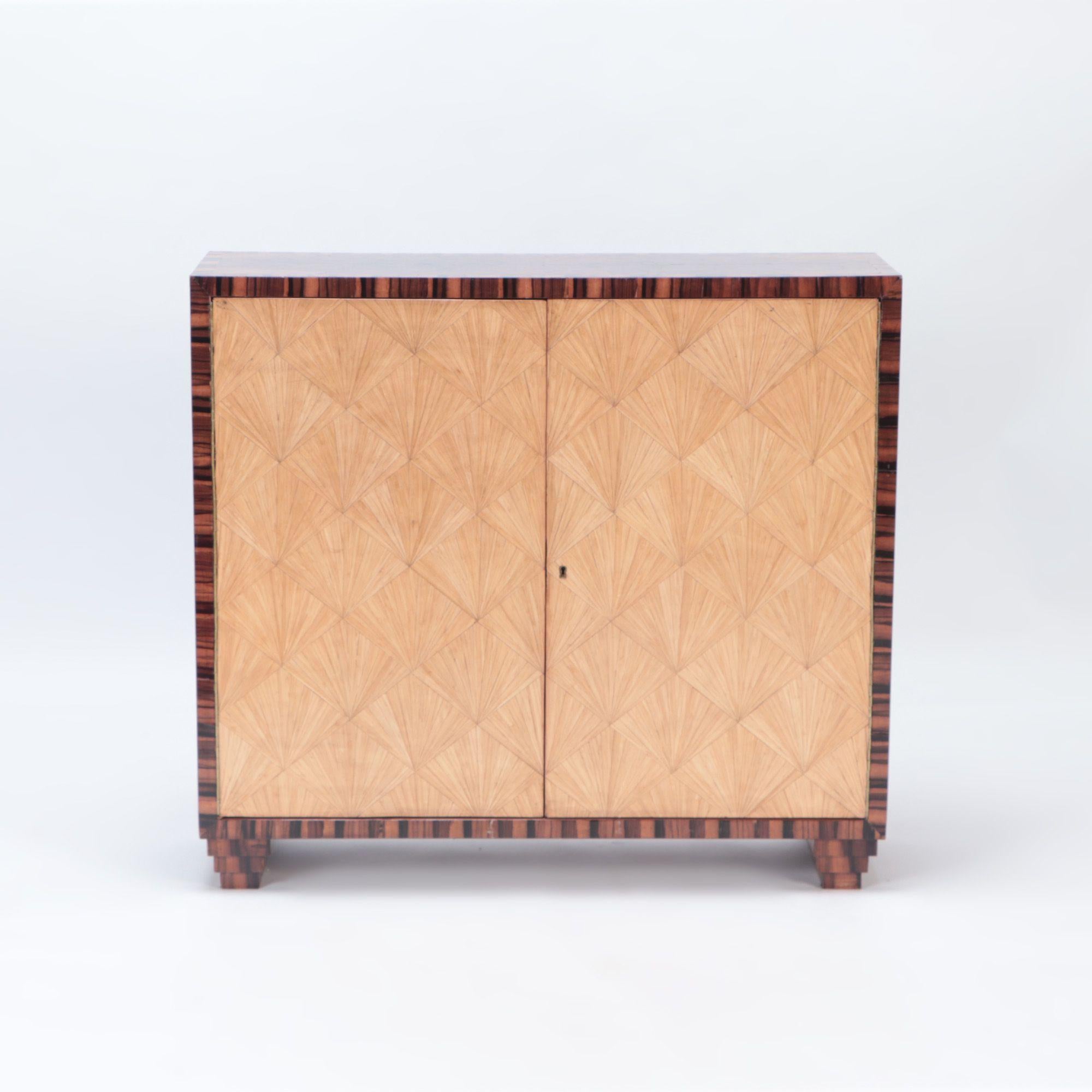 A beautiful pair of inlaid cabinets in the manner of Jean Michel Frank. The top is in burl walnut and bordered in rosewood and the doors have straw marquetry inlay of bleached mahogany.