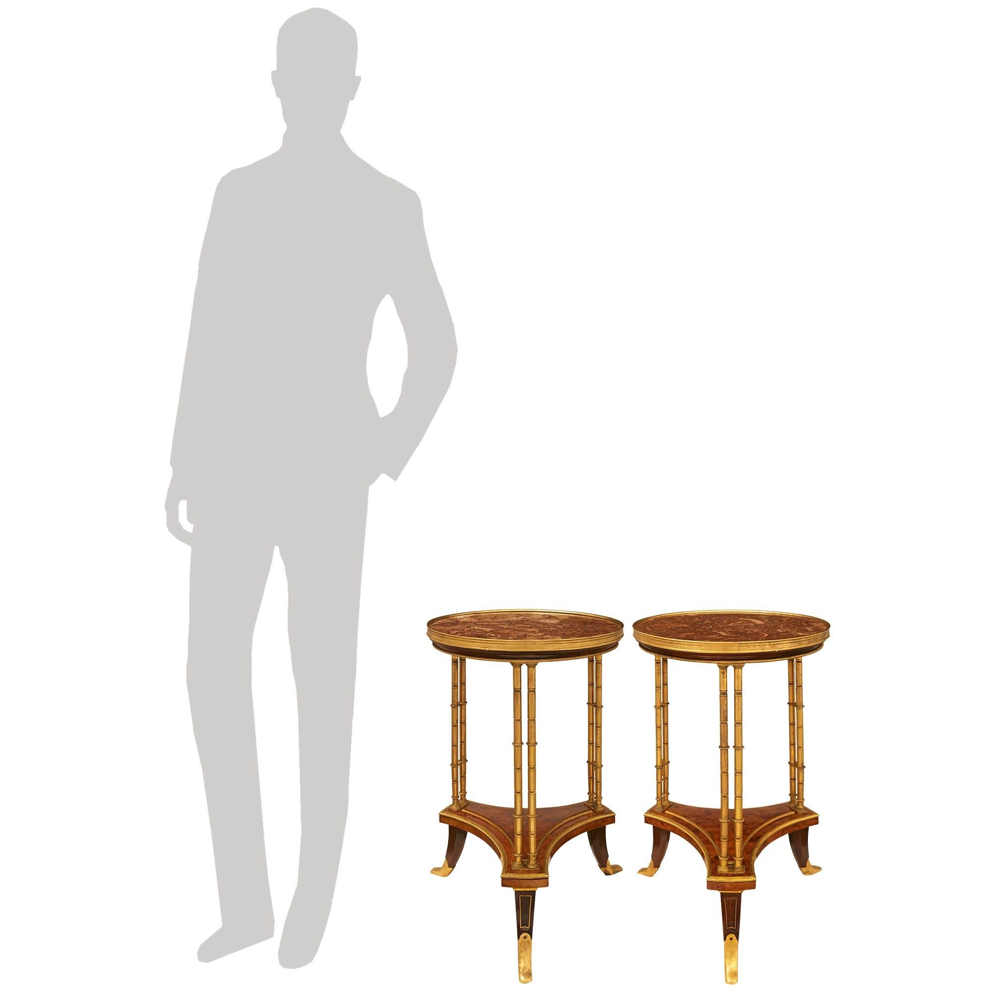  Très belle paire de tables d'appoint de style Louis XVI du XIXe siècle, en ronce de noyer, acajou, bronze doré et marbre brèche. Cette paire de tables Guéridon des plus élégantes est modelée d'après l'original du maître Ébéniste, Adams Weisweiler.