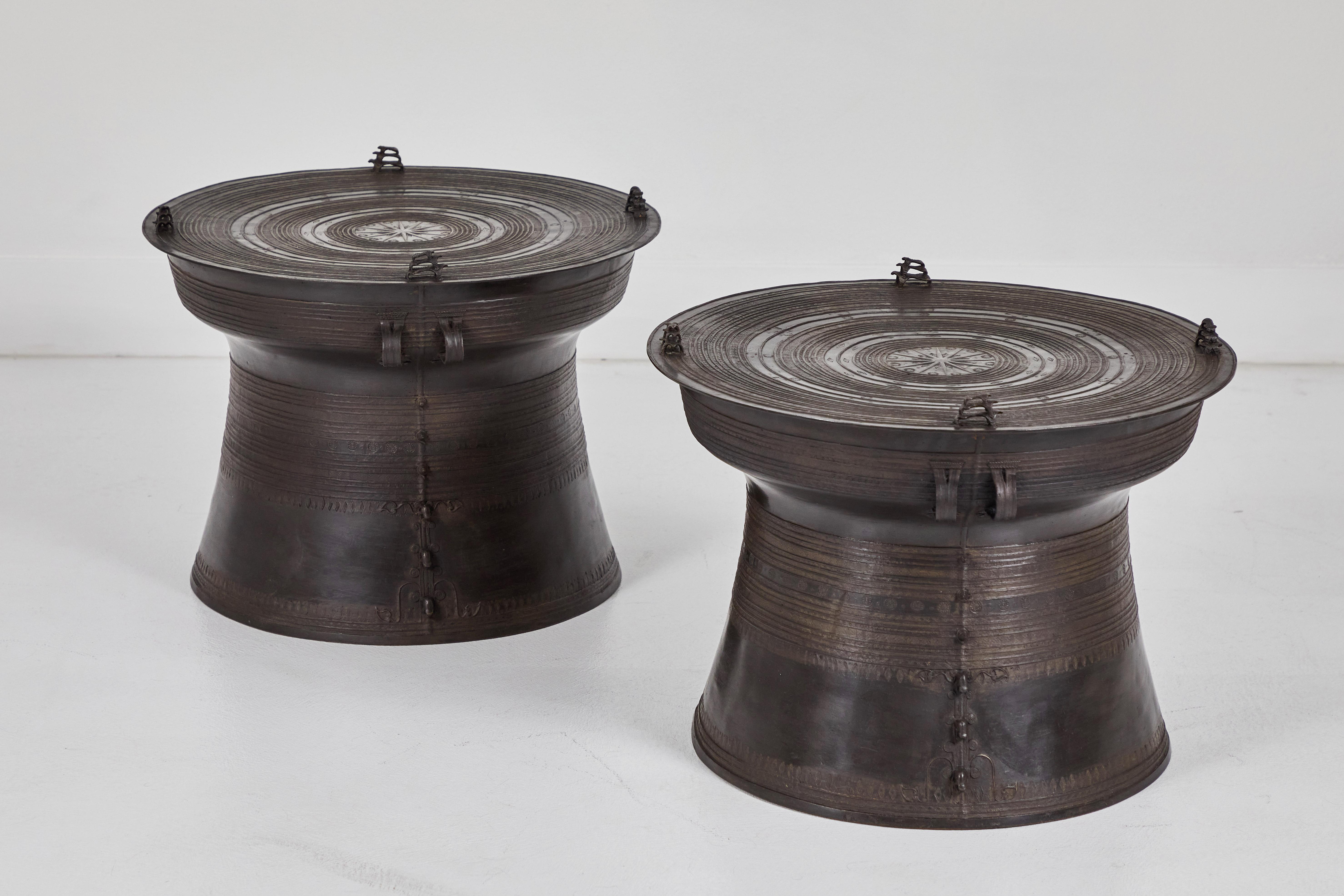 This pair of cast brass Burmese rain drums typical of Eastern Burma are in wonderful condition. They are intricately decorated through out on the top and the base. The base tapers out and the traditional starburst design is in the center on the top.