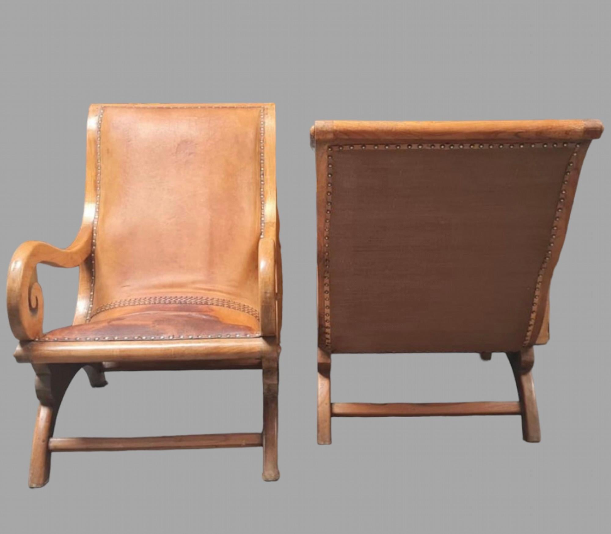 A Pair of Very Attractive Plantation Fruitwood c1900 Armchairs with scrolling arms upholstered in studded tan leather and professionally upholstered matching hessian backs.