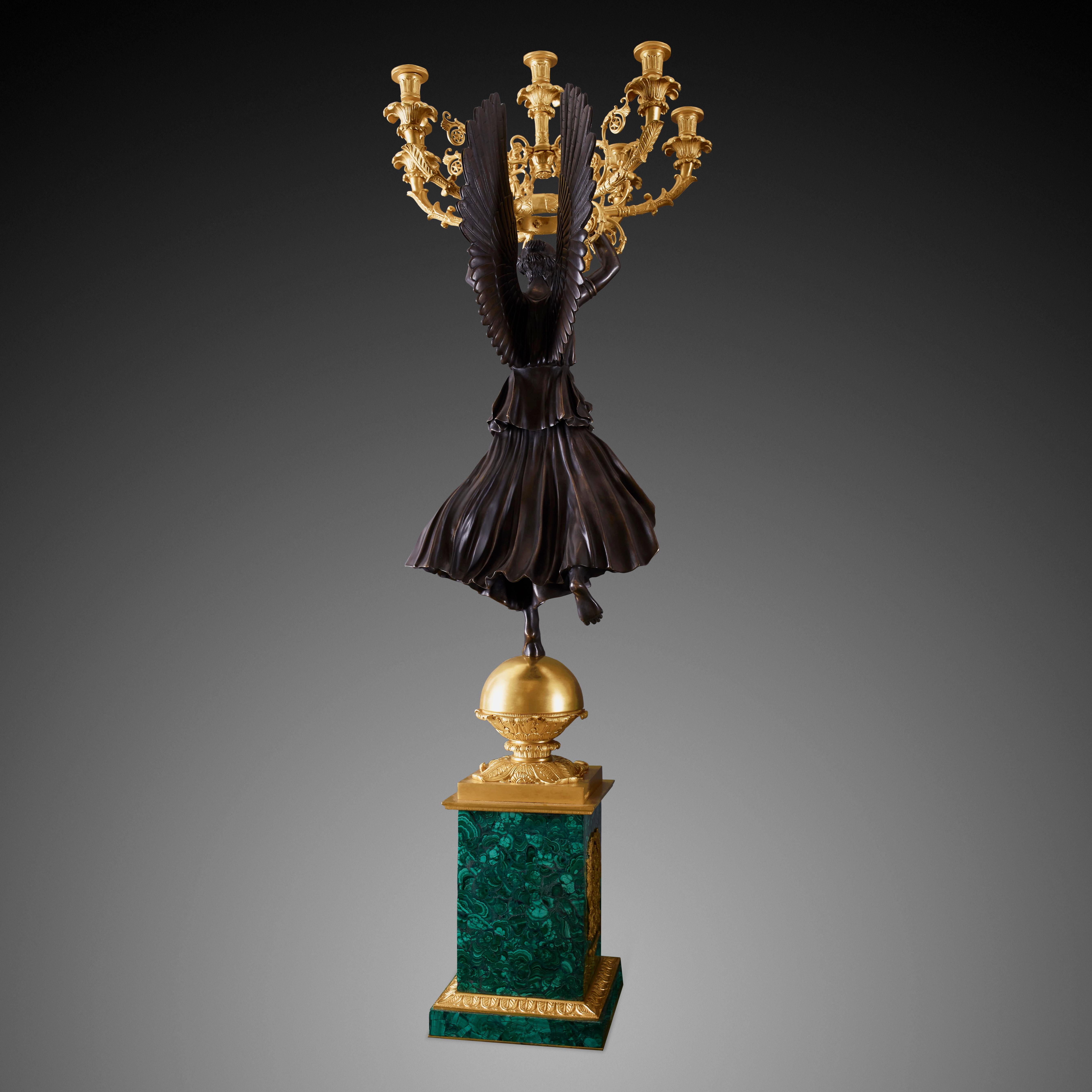 This stunning pair of candelabras comes in a set with equally beautiful mantel clock. This pair of early French empire candelabra were crafted using the two most luxurious ingredients globally: Bronze and Malachite, which creates a magnificent