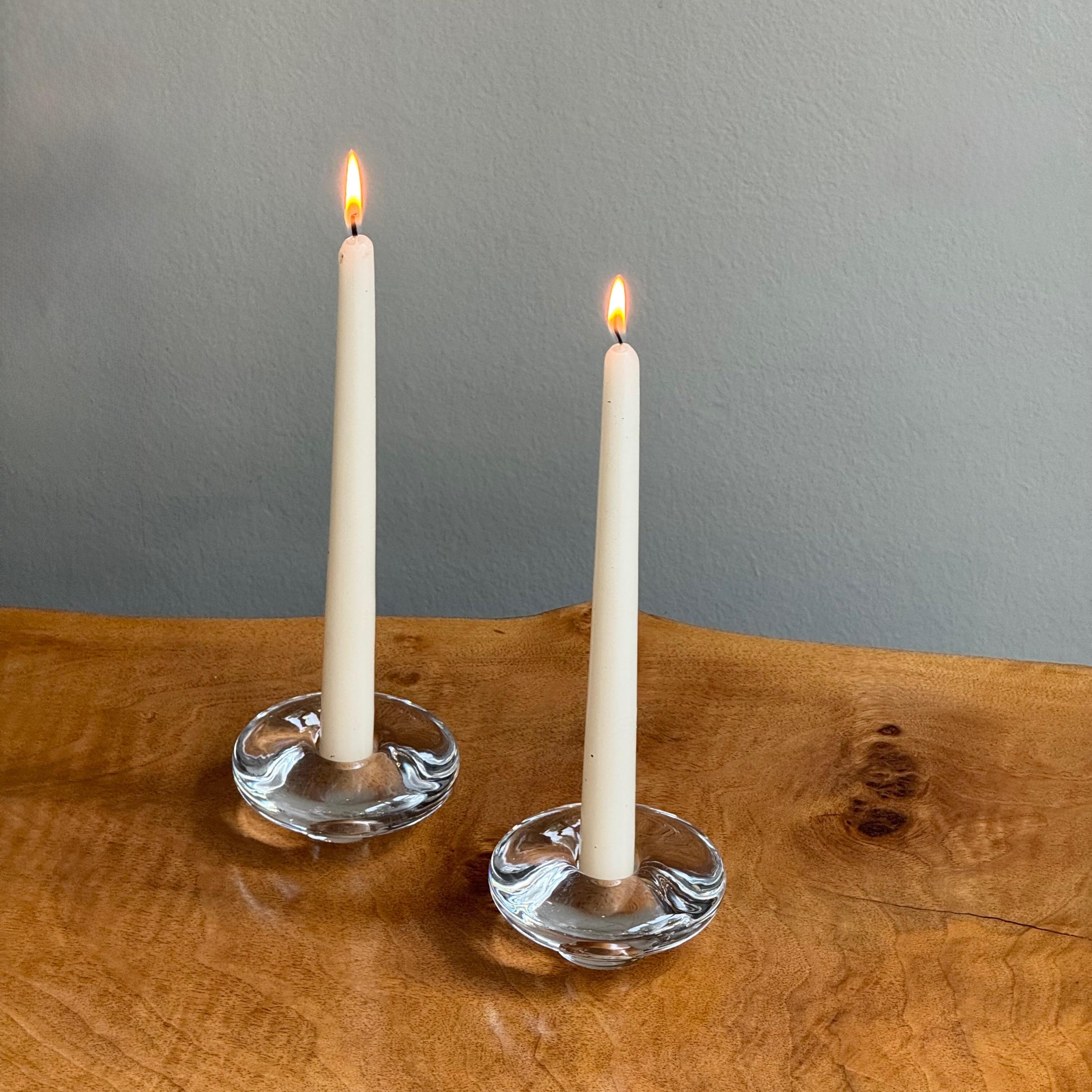 Description:

A pair of candle holders made by Swedish glass manufacturer Orrefors during the mid-late 1950s. 

This pair of delightfully tactile, solid glass candle holders are typical of the small glass pieces produced by the prestigious Swedish