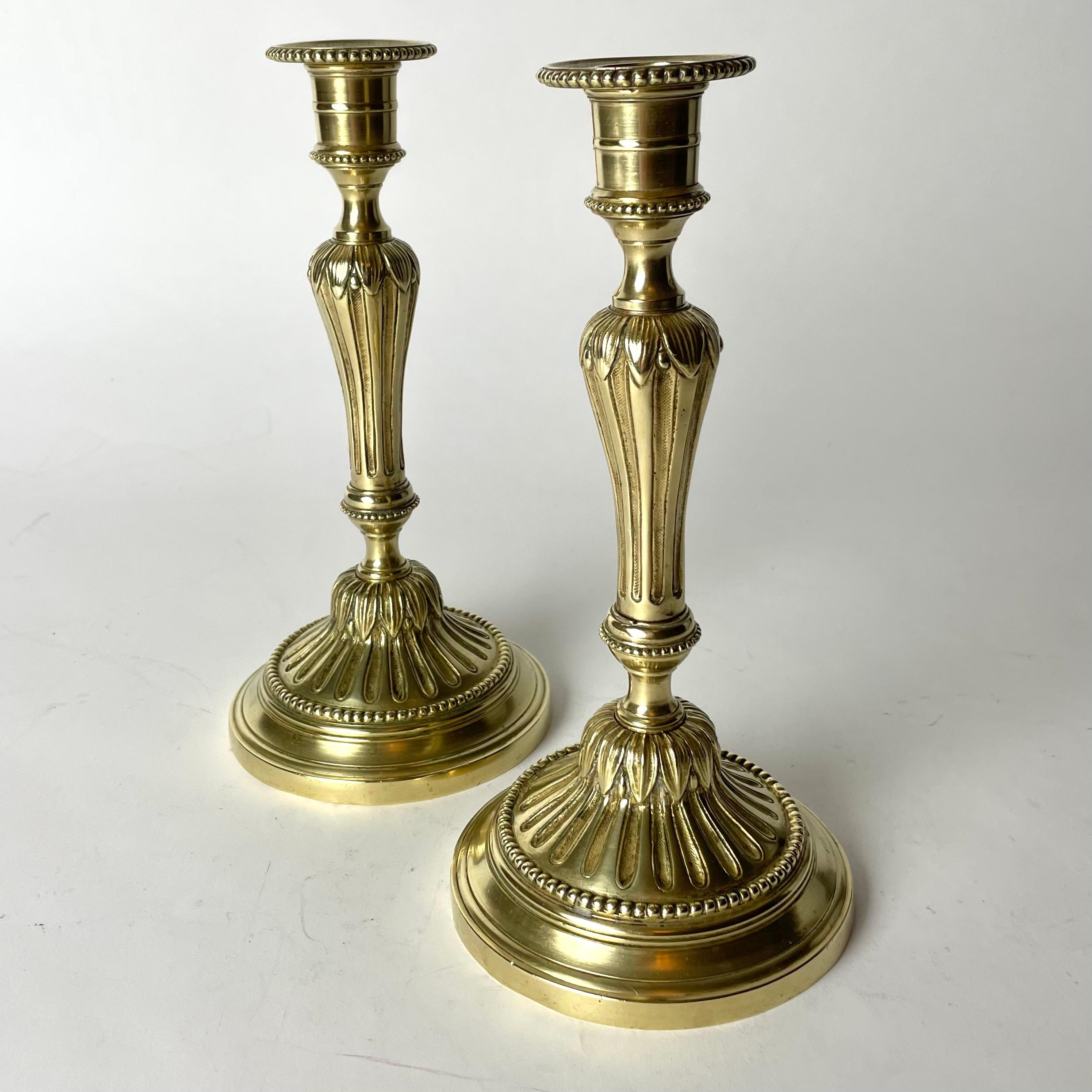 A Pair of Elegant and Ornate Brass Candlesticks from early 20th Century. In the style of Louis XVI.


Wear consistent with age and use