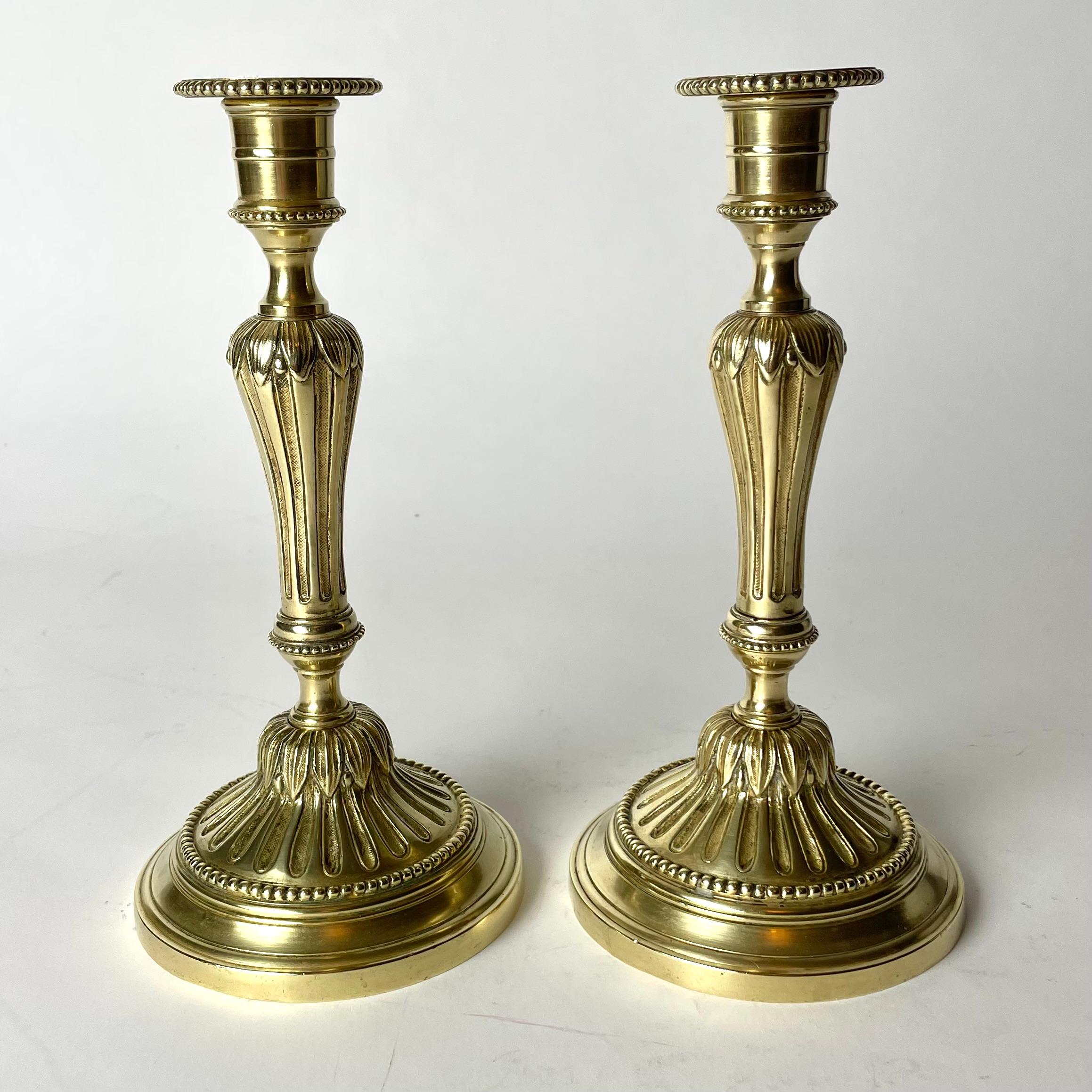 French A Pair of Candlesticks in brass, early 20th Century, in the style of Louis XVI For Sale
