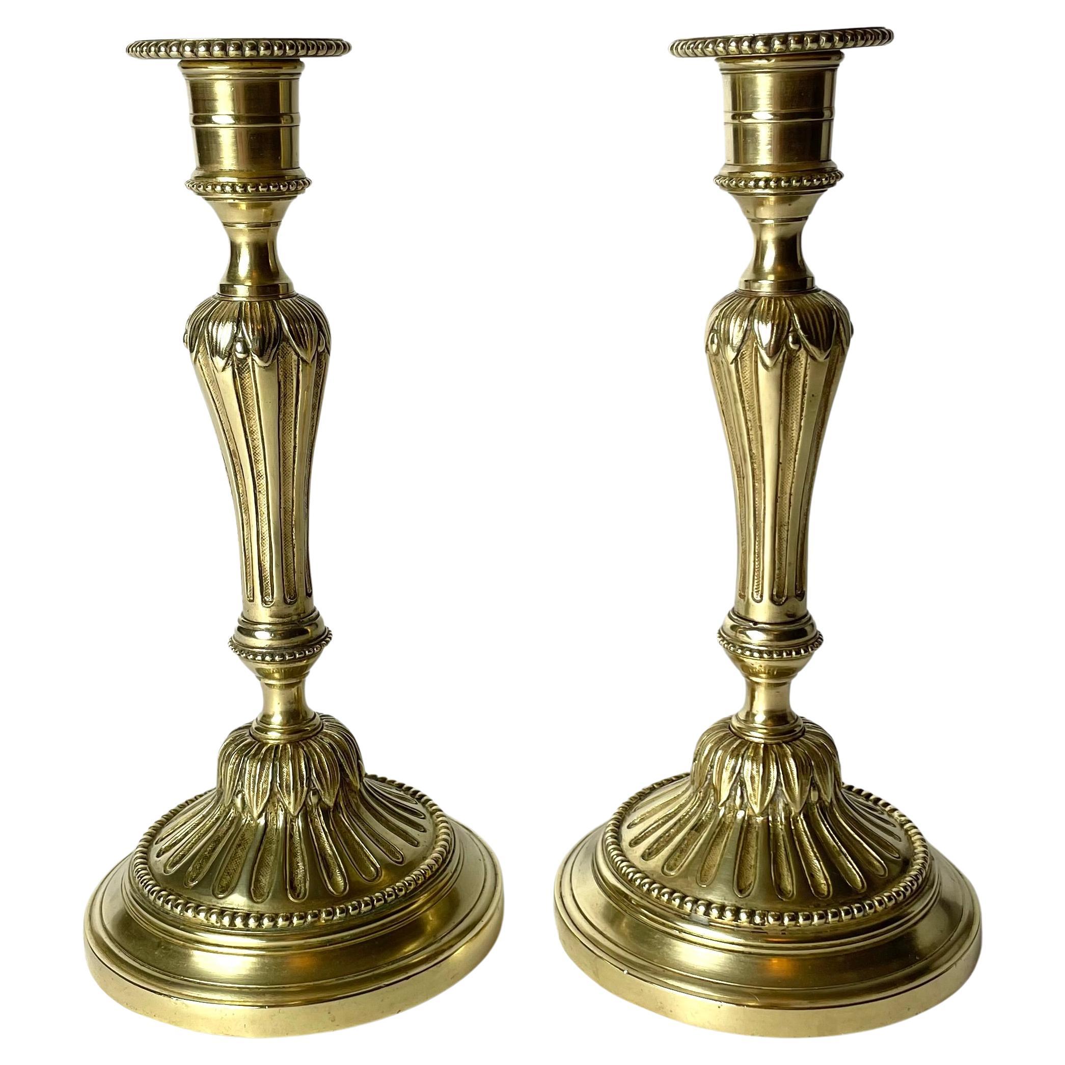 A Pair of Candlesticks in brass, early 20th Century, in the style of Louis XVI For Sale