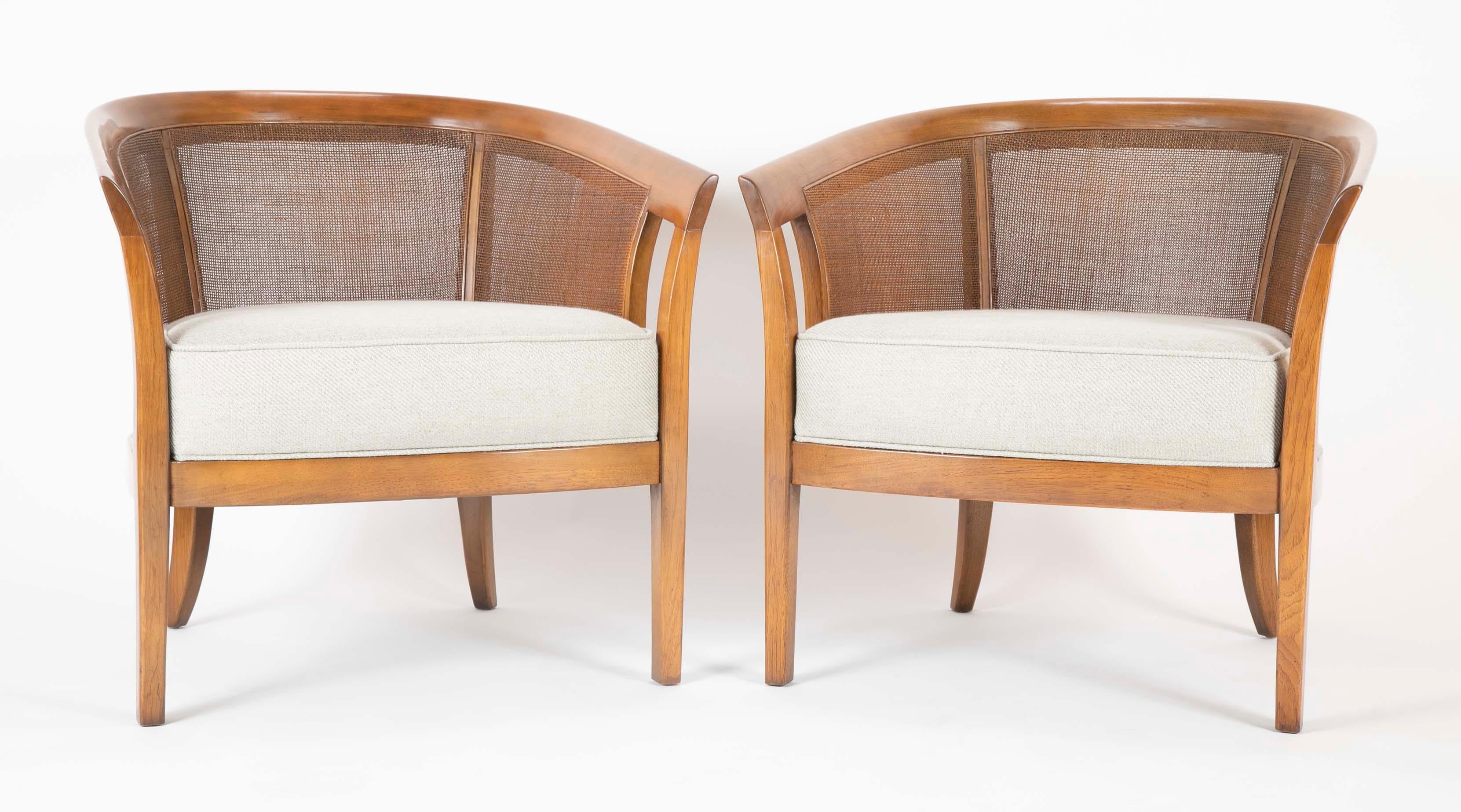 A pair of walnut Edward Wormley designed armchairs produced by Dunbar. Cain sides and backs with Rogers & Gofigon cushions.