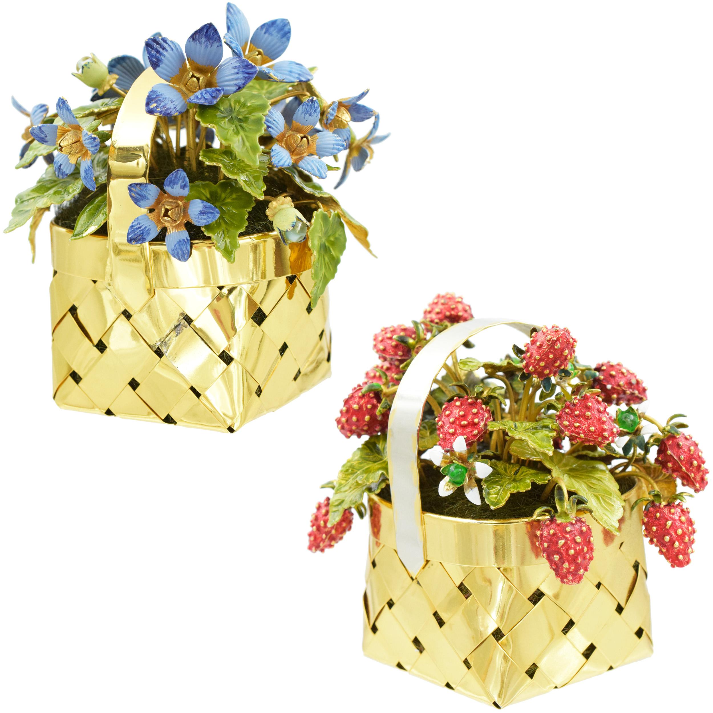 A pair of Cartier enamel and silver flower and fruit baskets. Circa 1950.
One of the baskets features strawberry plants with the fruits. The second basket features a plant with blue flowers. The pieces are accented with various colors of enamel and