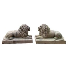 Pareja de leones yacentes tallados en piedra marrón al estilo del arte popular americano