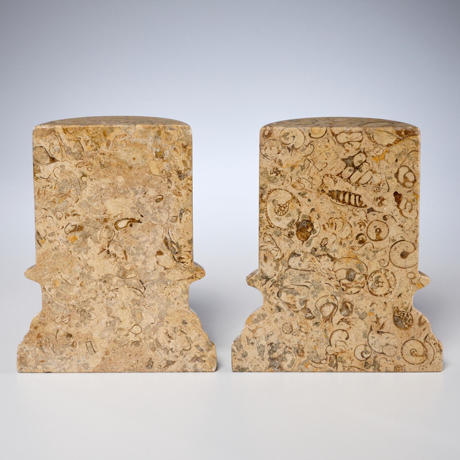 20th c., a high quality pair of demilune columnar form stone bookends, unmarked. Skillfully carved beige limestone with a large number of spiral shell gastropods, nautiloids, and other fossils polished to show off the beauty of the fossils. There