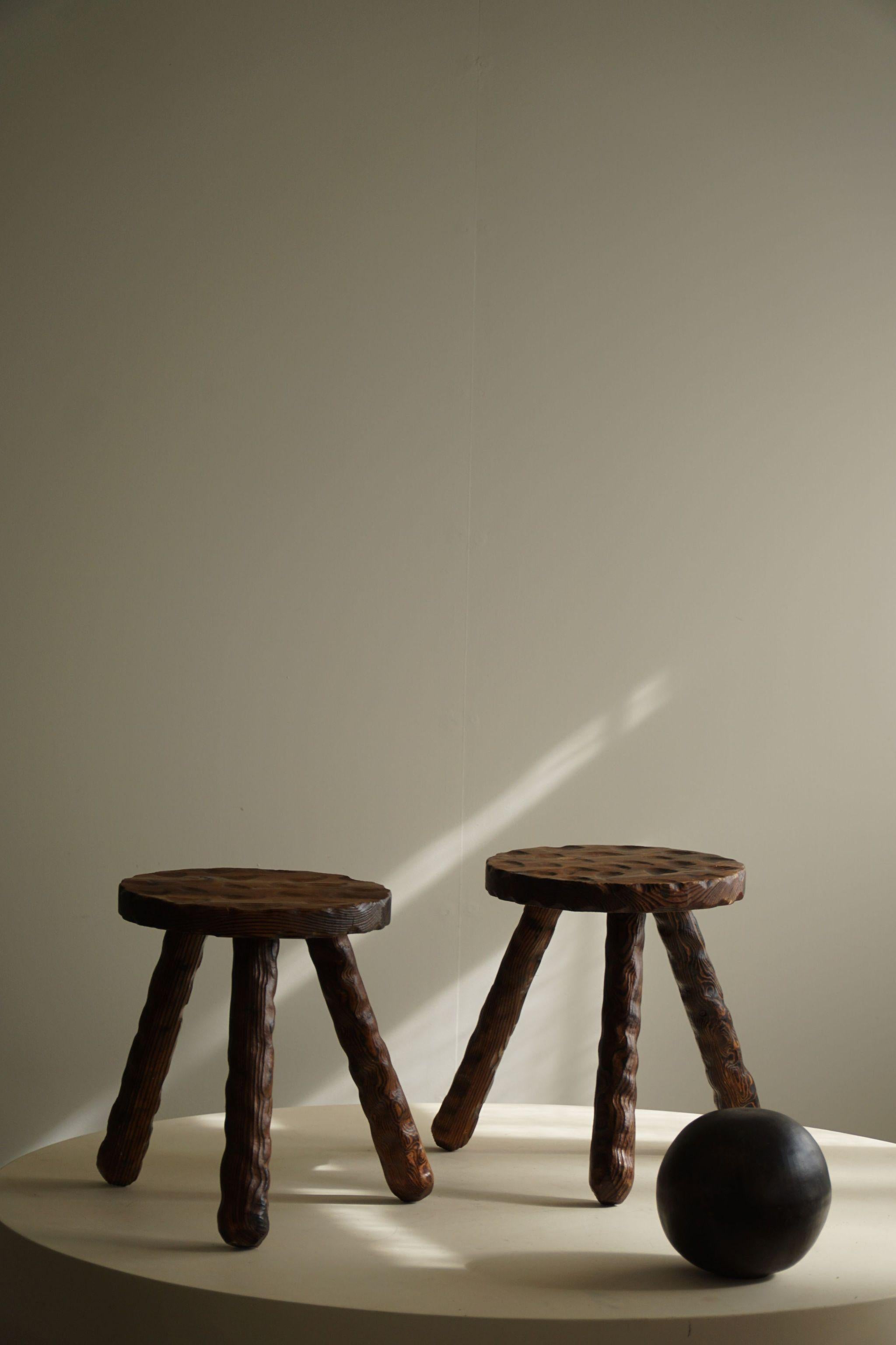 A duo of Wabi Sabi stools, expertly carved from stained pine by a skilled Swedish cabinetmaker during the 1960s. These stools boast a minimalist aesthetic with subtle imperfections that celebrate the beauty of natural materials. Their clean lines