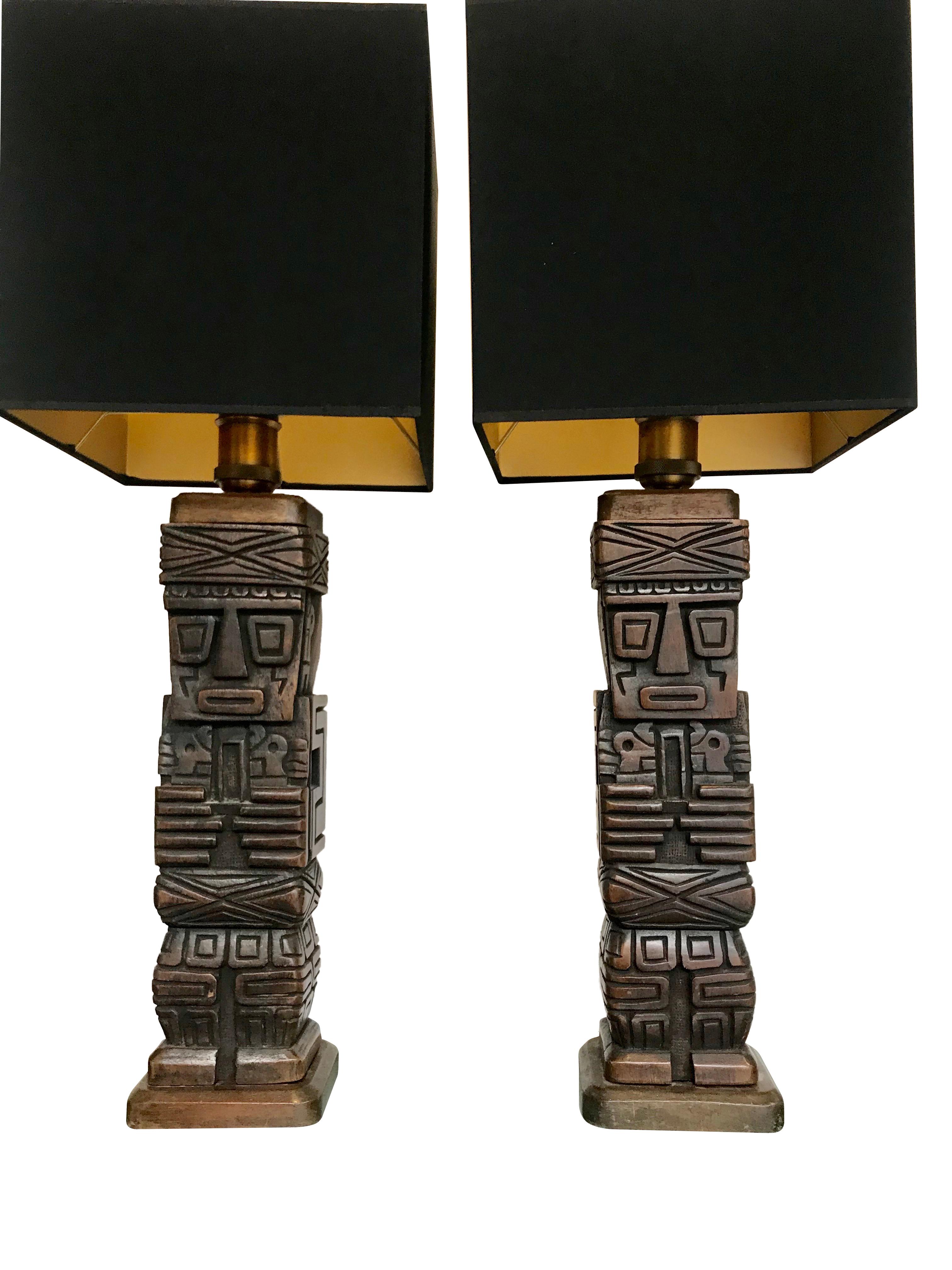 A pair of carved wooden Tiki lamps with brass fittings. Available with new bespoke in either black or Ivory with gold linings.