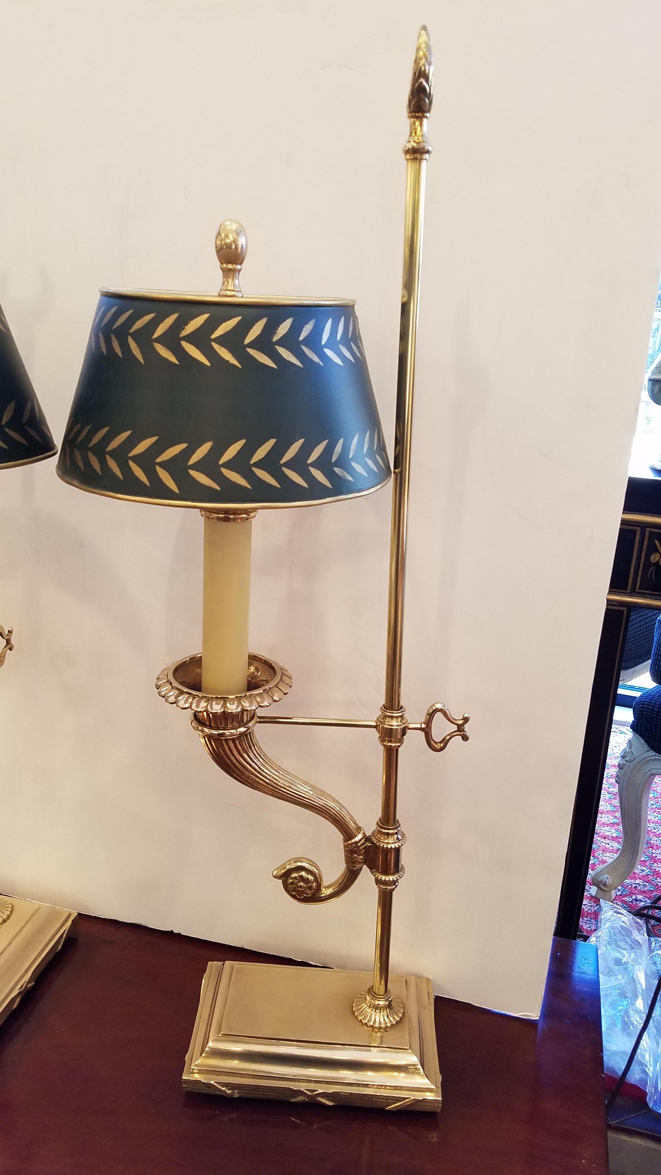 Gorgeous pair of neoclassical styled candlestick lamps by Chapman. The high quality cast brass lamps with green and gold hand painted tole oval shades. The cornucopia center support with a nicely detailed platform base, high end beautifully styled