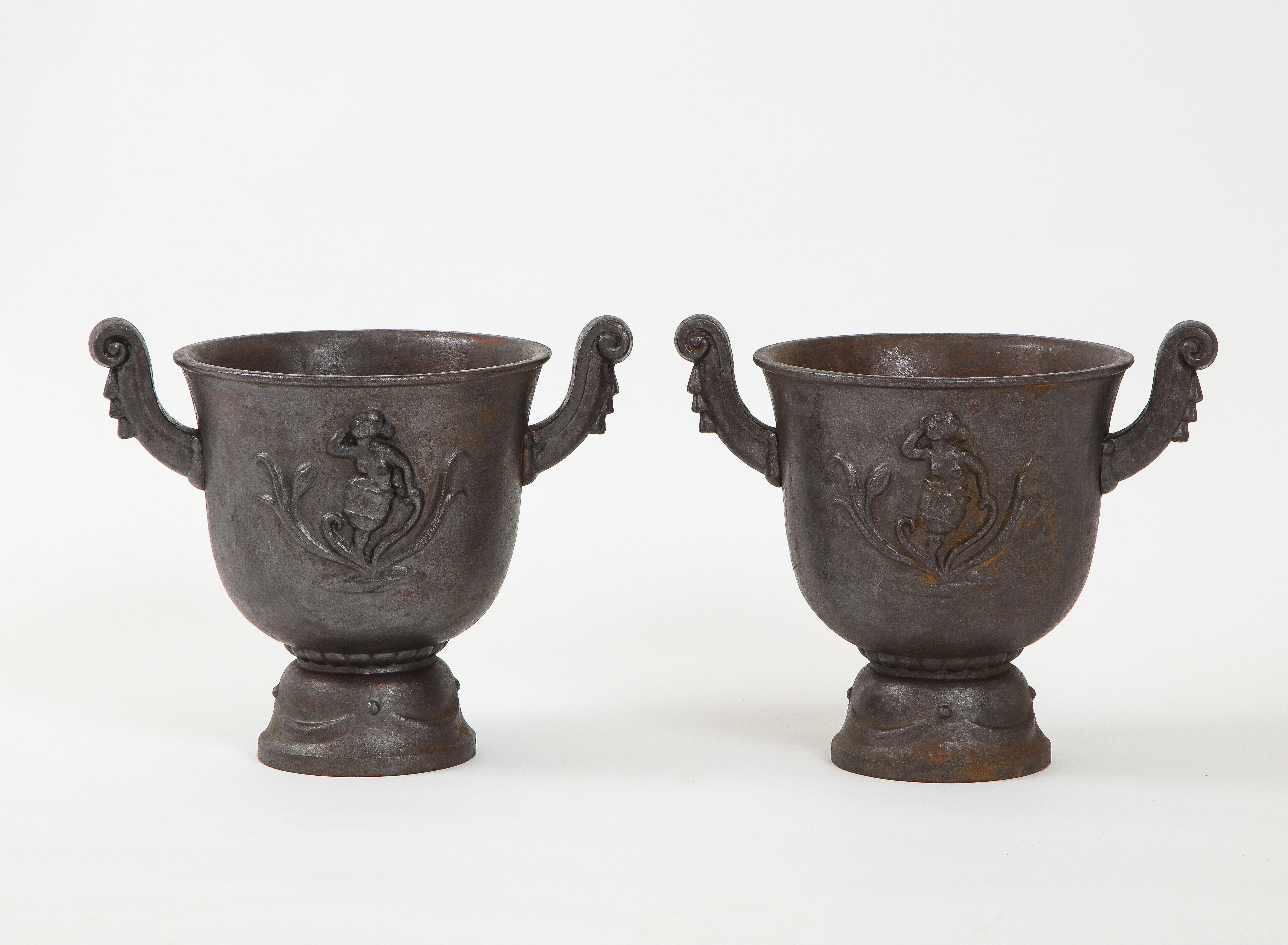 A pair of cast iron jardenière, “faunurna” designed by Ivan Johnsson (Sweden 1885-1970) and produced by Näfveqvarn foundry. Cast with classical motifs and figures. Wonderful patina. diam. base 10in. Näfveqvarn foundry is one of the oldest foundries