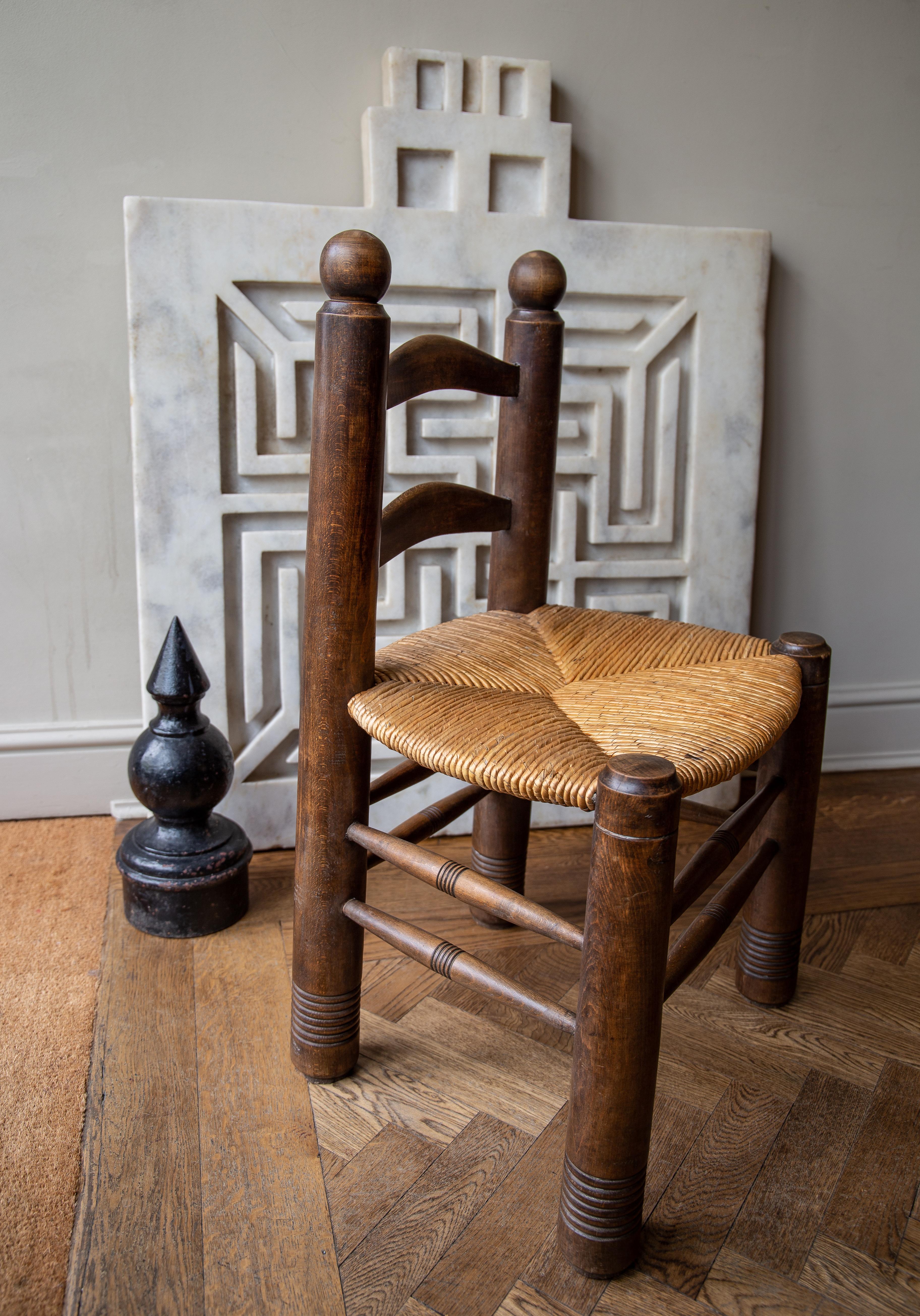 Reminiscent of the style of Perriand, yet with stout sculptural/architectural form with distinctive wide barrel turned frame and legs. Featuring beautiful pattern handwoven rush seat. Solid dense walnut construction - these chairs are heavy for