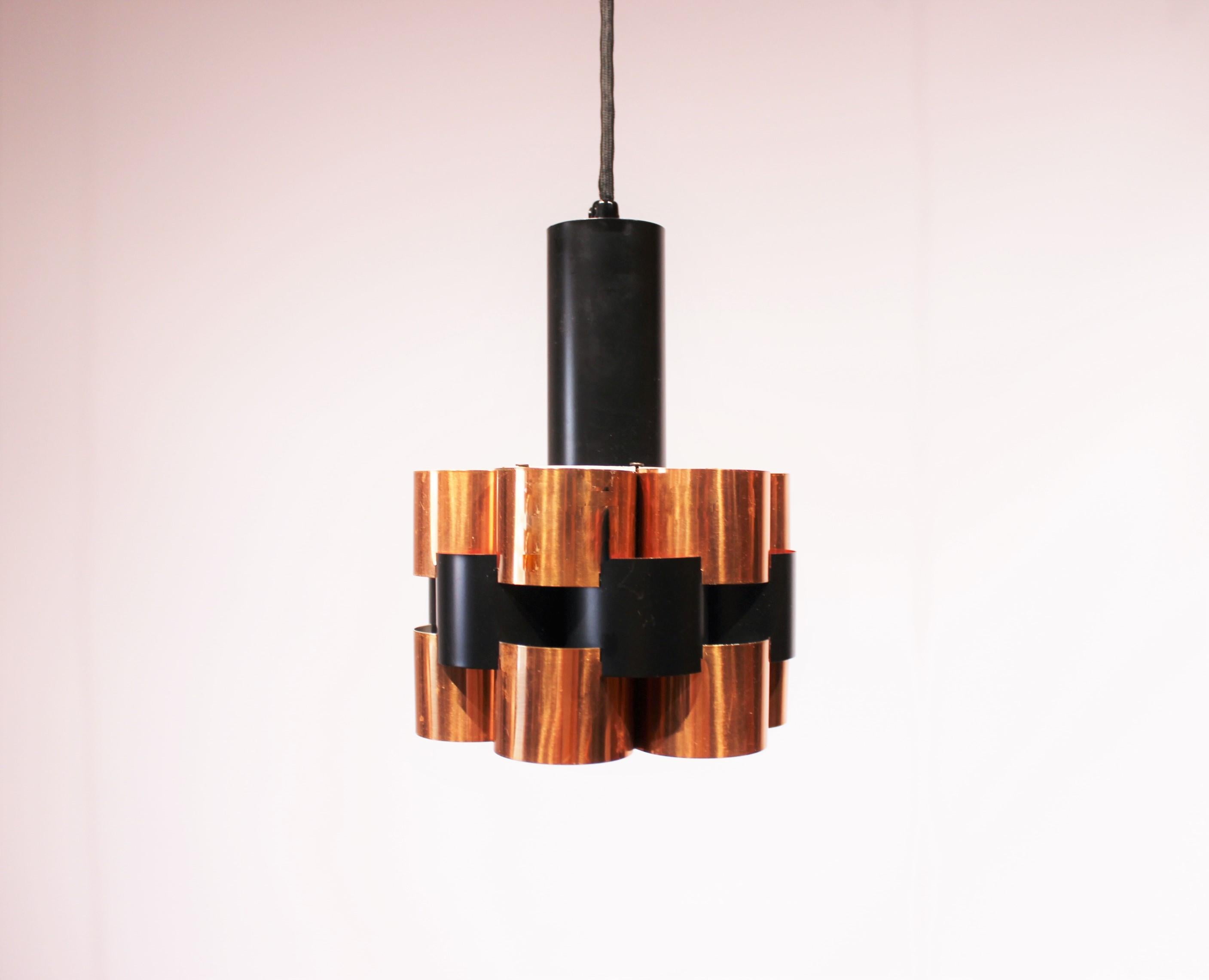 These ceiling pendants, crafted in copper and black lacquered metal, epitomize the sleek elegance of 1960s design. Designed by Werner Schou, they boast a harmonious blend of materials and colors that exude sophistication. 

The warm hue of copper