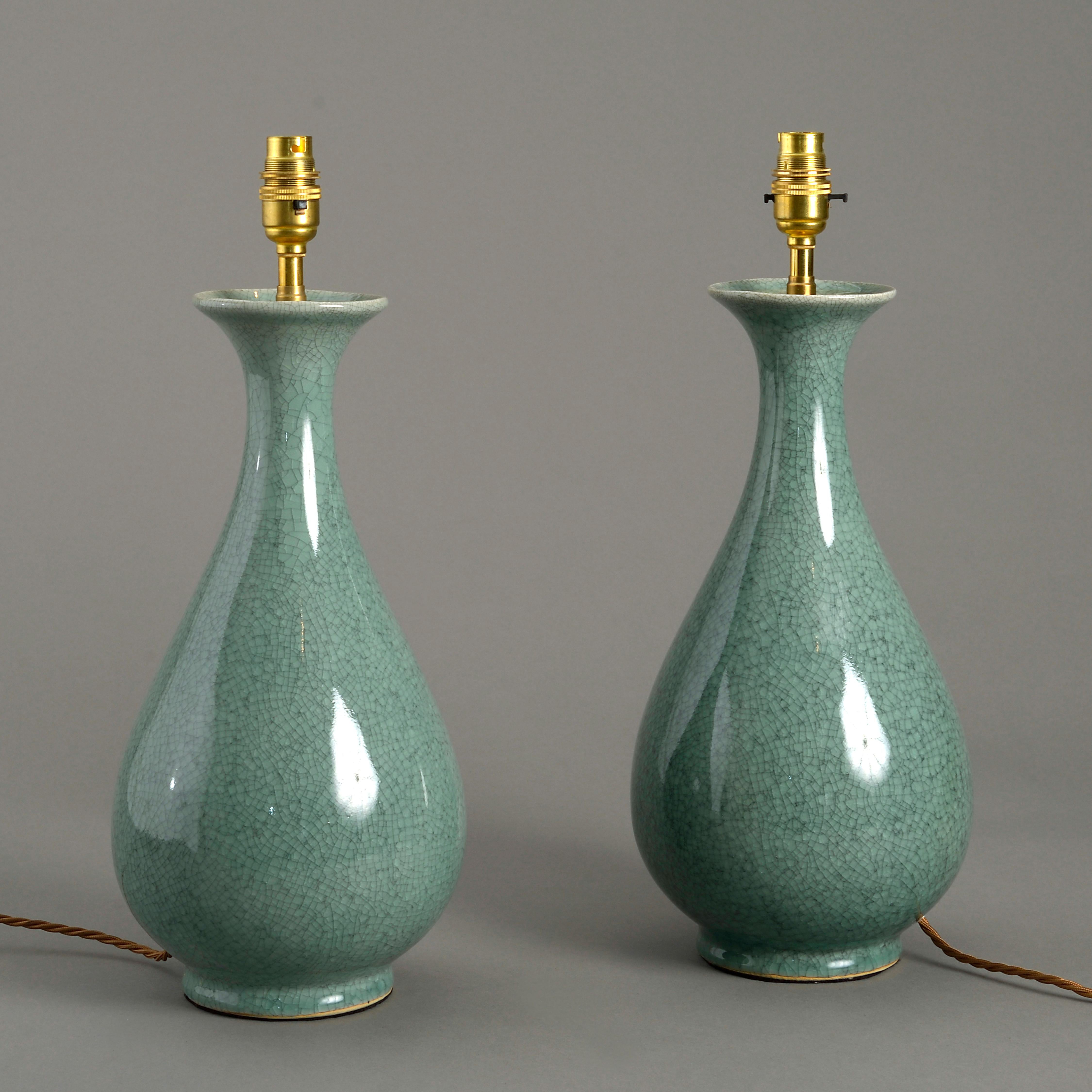 A pair of celadon crackle glazed porcelain pear drop shaped vases of good scale, now mounted as lamp bases.

Dimensions refer to size of vase excluding electrical elements.

  