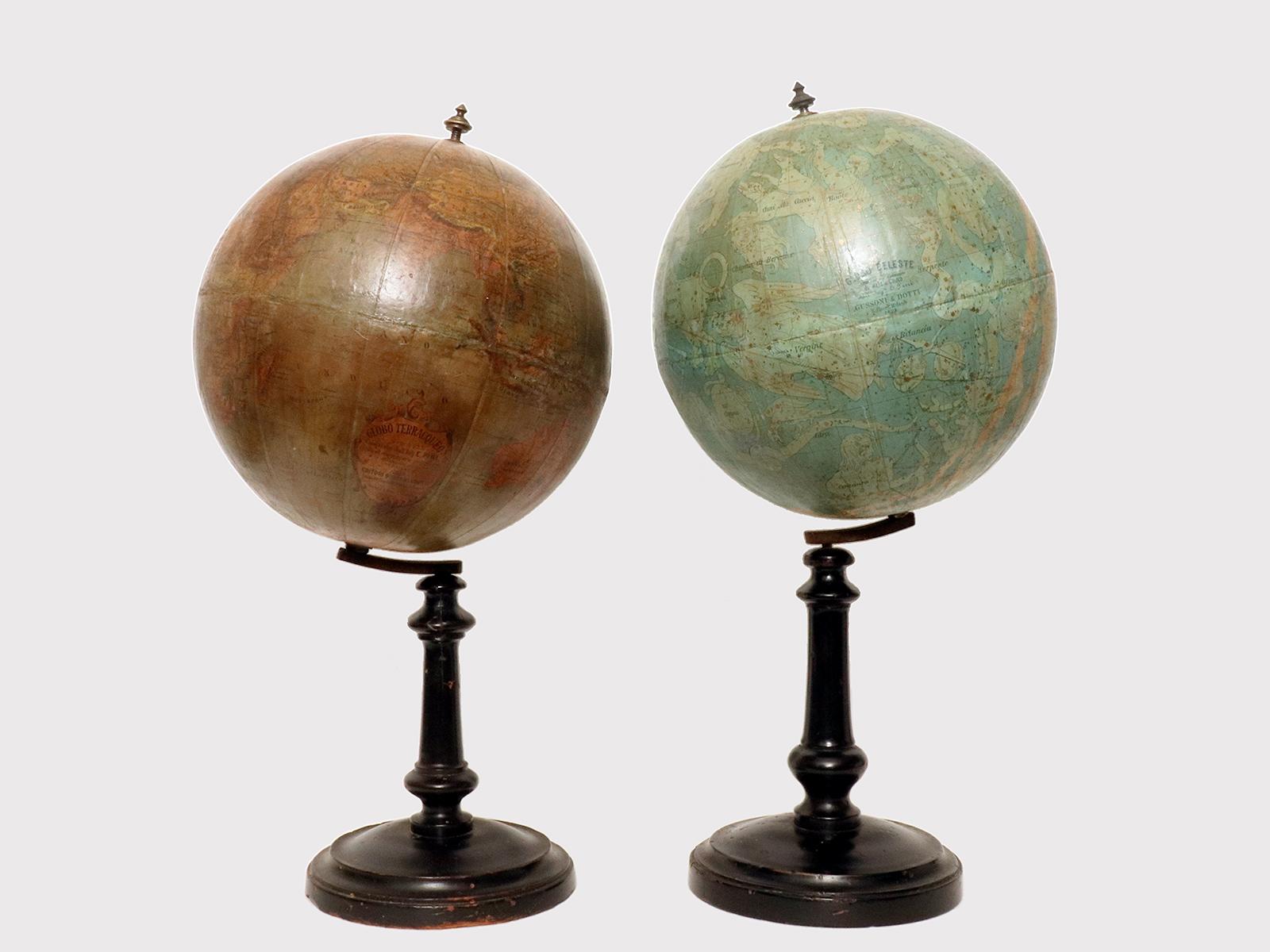 Pair of Italian globes. On an ebonized wooden base, worked on the lathe, with a circular foot and perfect patina, are placed: a celestial globe of 9,2 inches, compiled by the engineer E. Pini based on the catalogs of Heis and Gould, published by