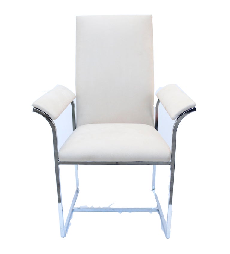 A pair of Cal-Style chrome-framed chairs in off-white grainy leather with curved armrests.