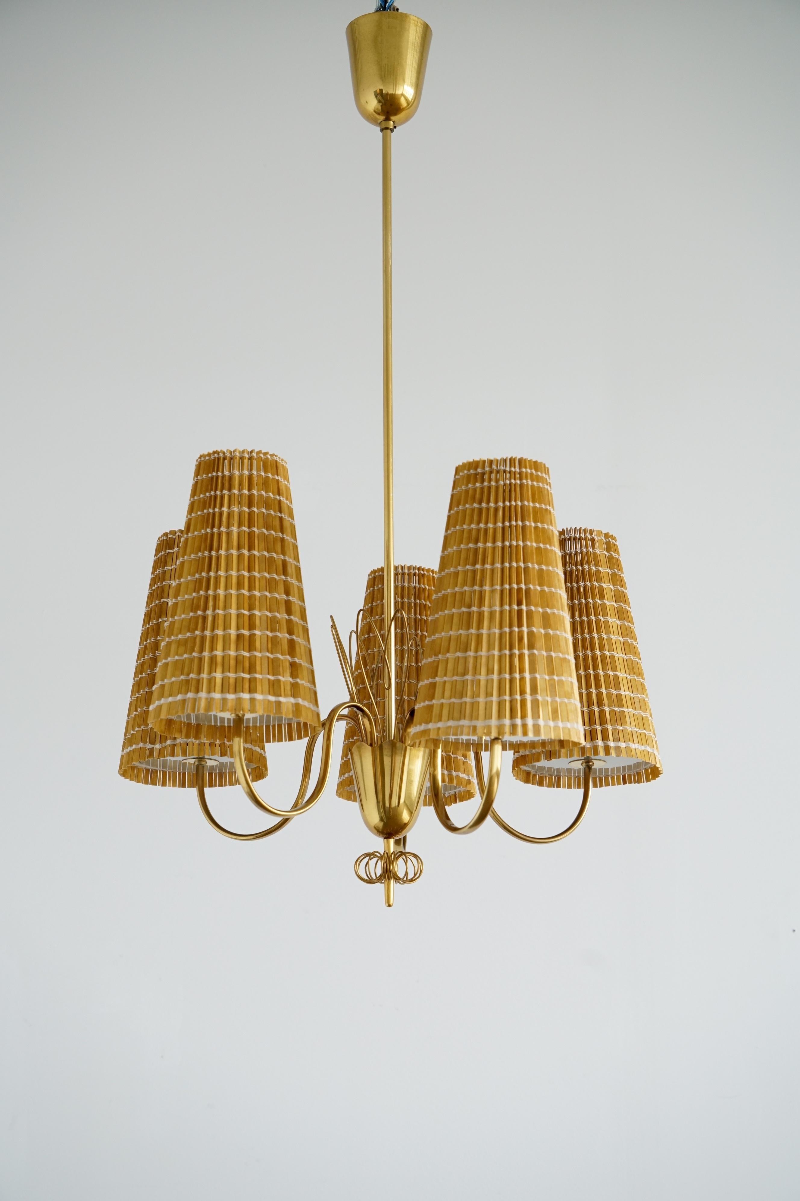 A pair of Chandeliers deigned by Paavo Tynell (1890-1973) for Taito OY, Finland , circa 1950th. Model 9082. Brass, glass and wood slats shades.  Dimensions: H 40″ × Diam 23″. Existing wires, rewiring available upon request.