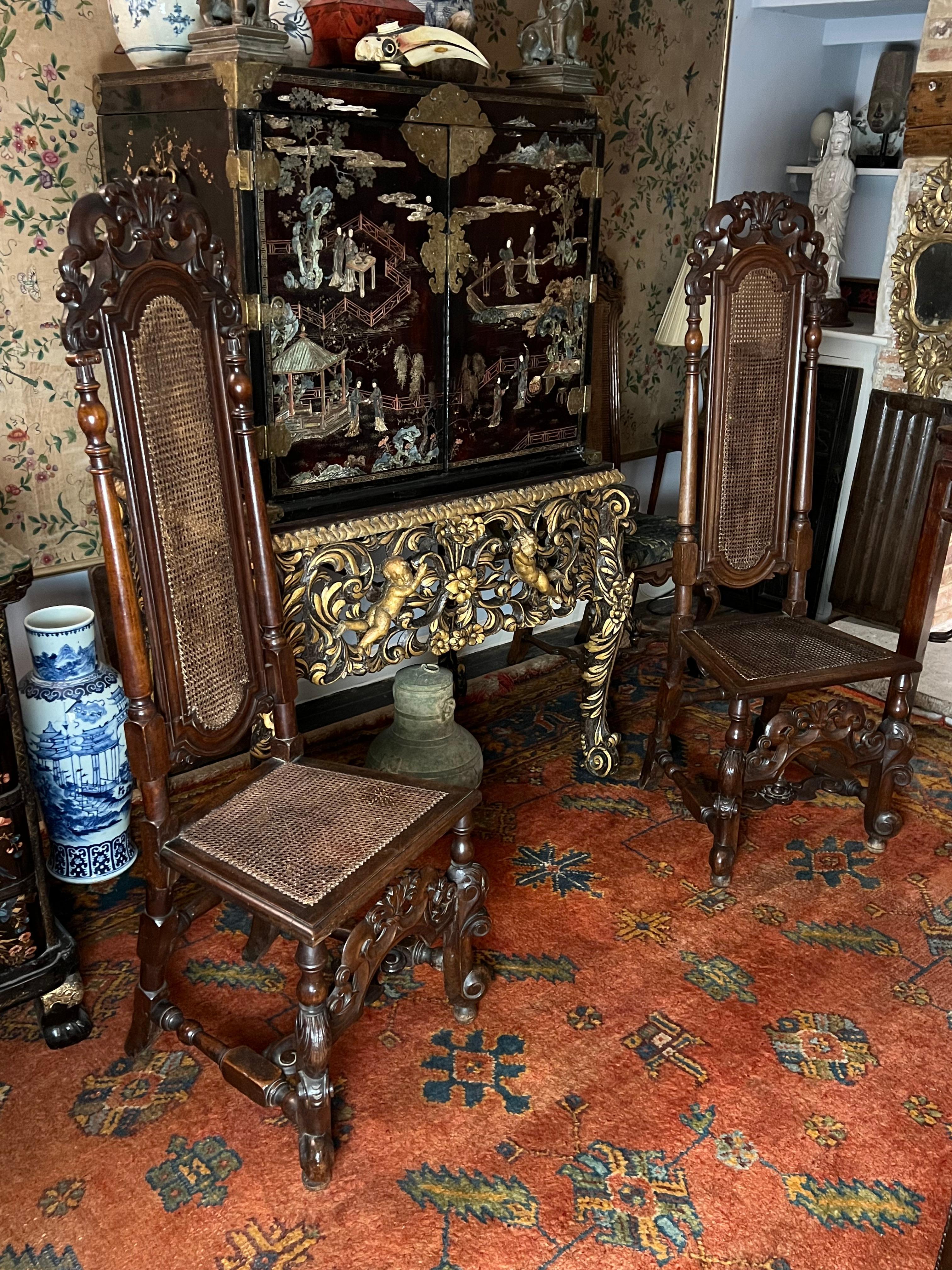 A good pair of English late-17th century walnut chairs. Charles II period, circa 1680.

Lovely waxed patinated surfaces and colour.

The upright, caned high backs well carved. The pierced foliate and scroll crestings vigorously carved in the typical