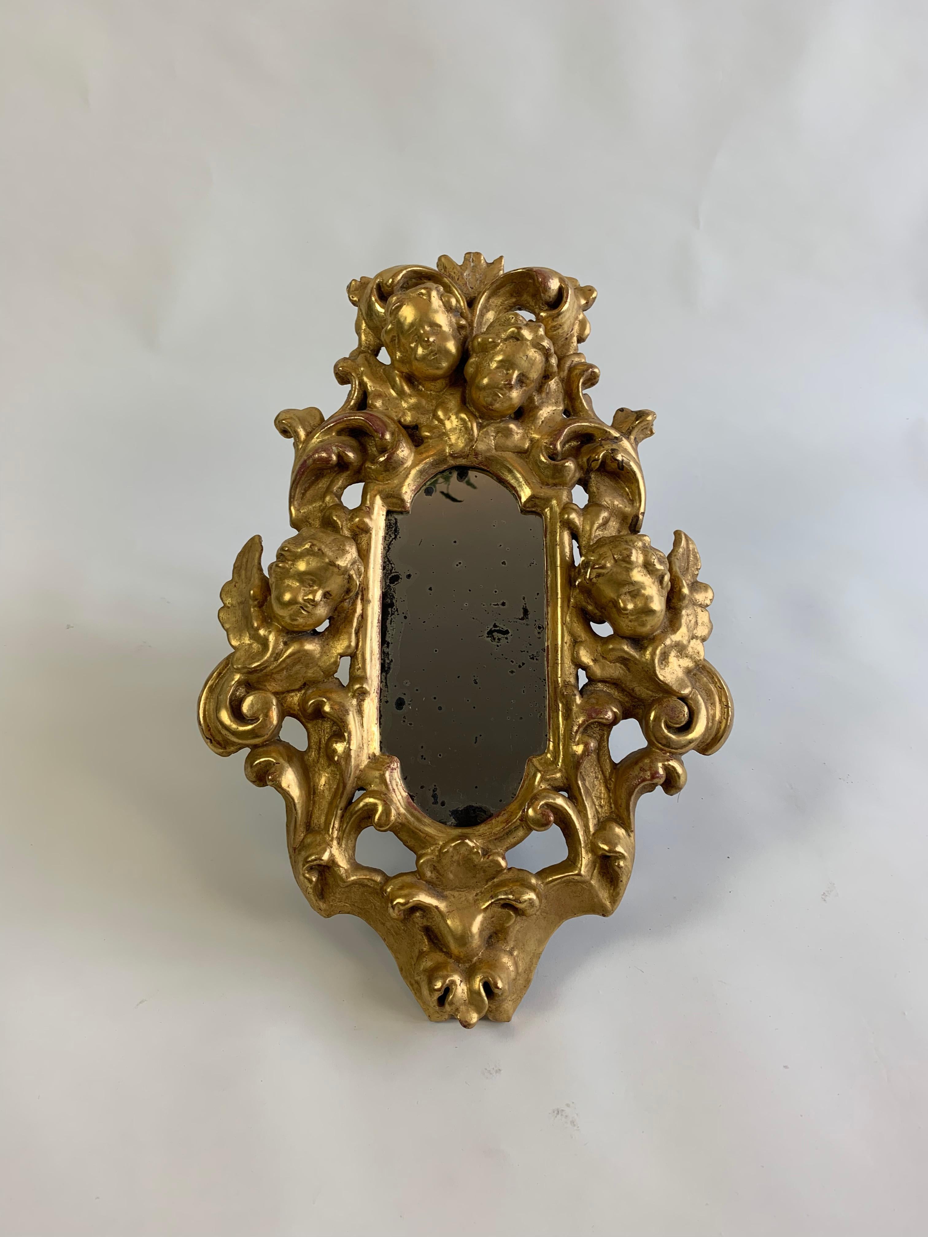 Paire de miroirs en bois doré de type Chérubin. En bon état, compte tenu de l'âge. Les miroirs ont une belle patine d'usage. Vendu en tant que paire assortie, mais il est possible de le vendre individuellement. 