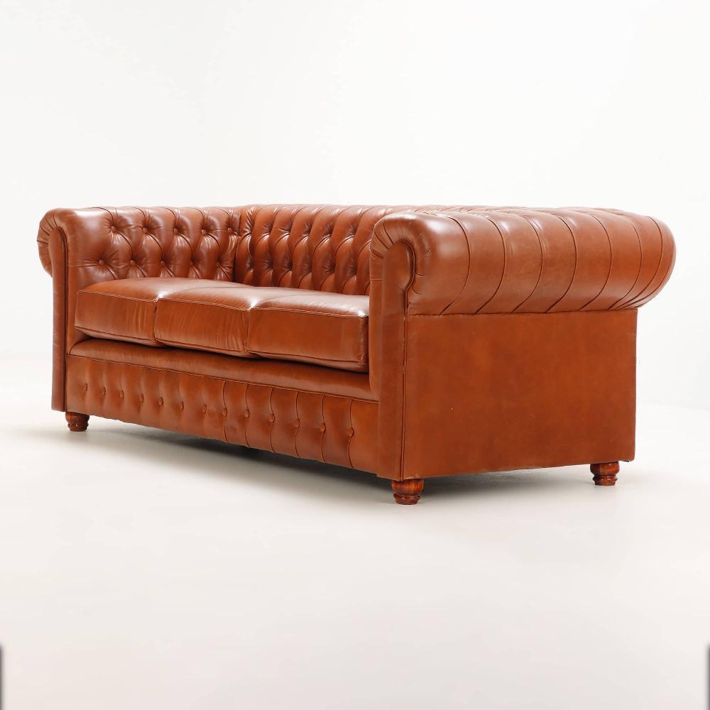 This timeless design is noted for the large rolled continuous back and arms, deep button tufting, three cushions, and short turned feet.