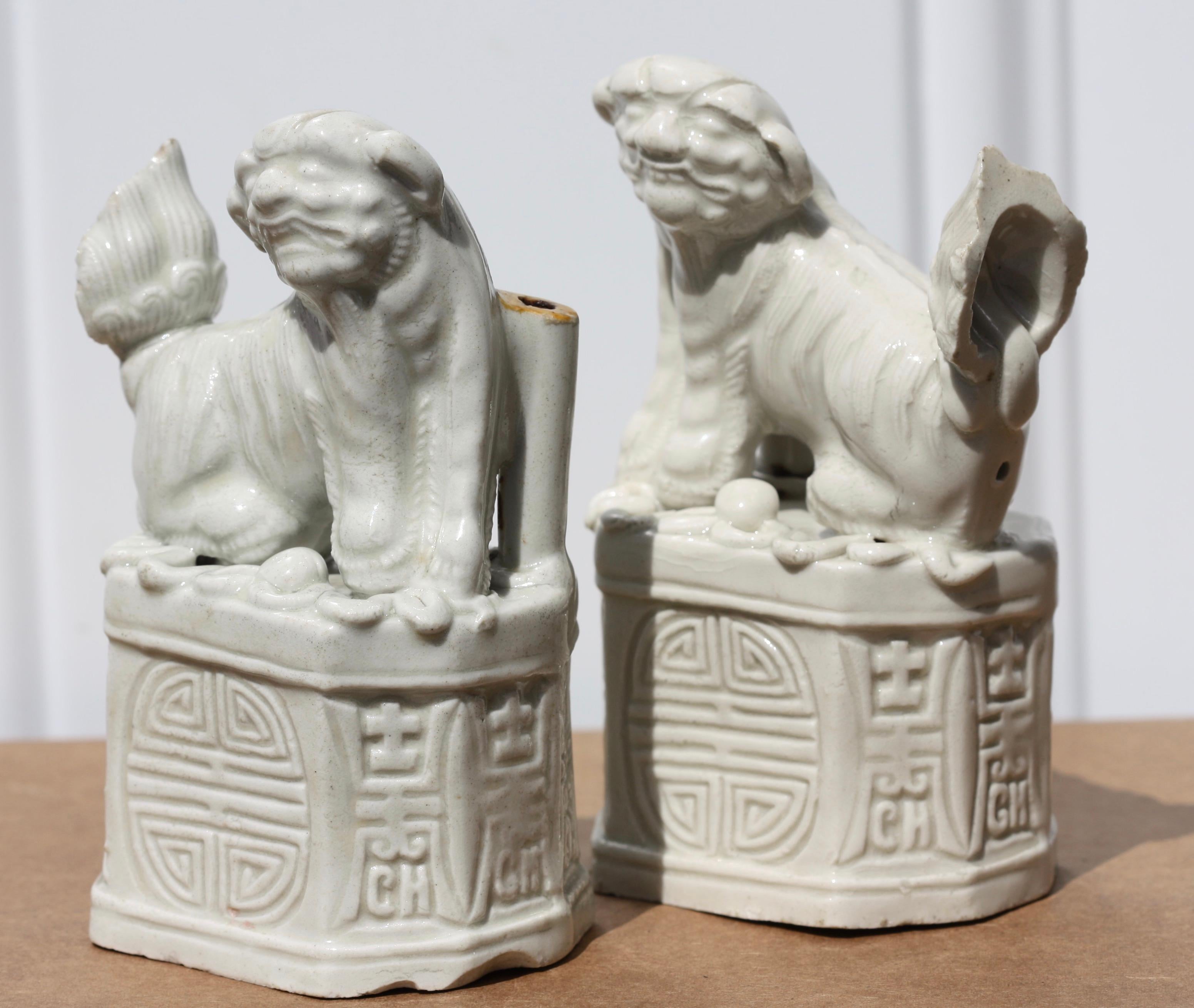 A pair of Chinese 'blanc-de-chine' 'Buddhist Lion' joss stick holders
probably Qing dynasty
Each superbly modeled seated in opposing poses above rectangular bases
Measures: Height 4.37 in. (11.1 cm.)
Width 2.55 in. (6.5 cm.).