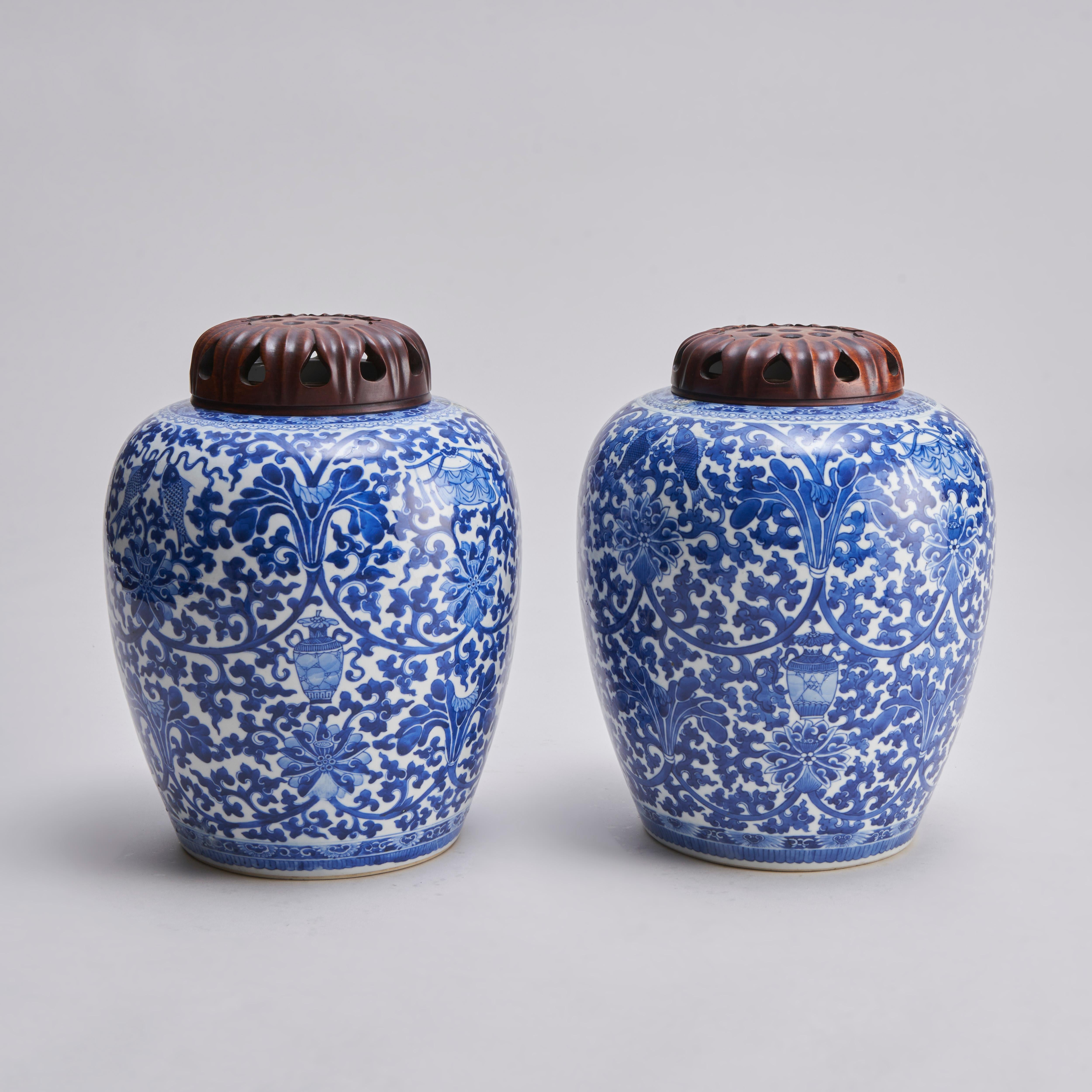 From our collection of antique Chinese porcelain, a pair of 19th century blue and white jars with wood covers.

The jars are decorated with lotus blossoms and foliate, among the foliage precious vases, fish and silks are entwined.

Contact us for